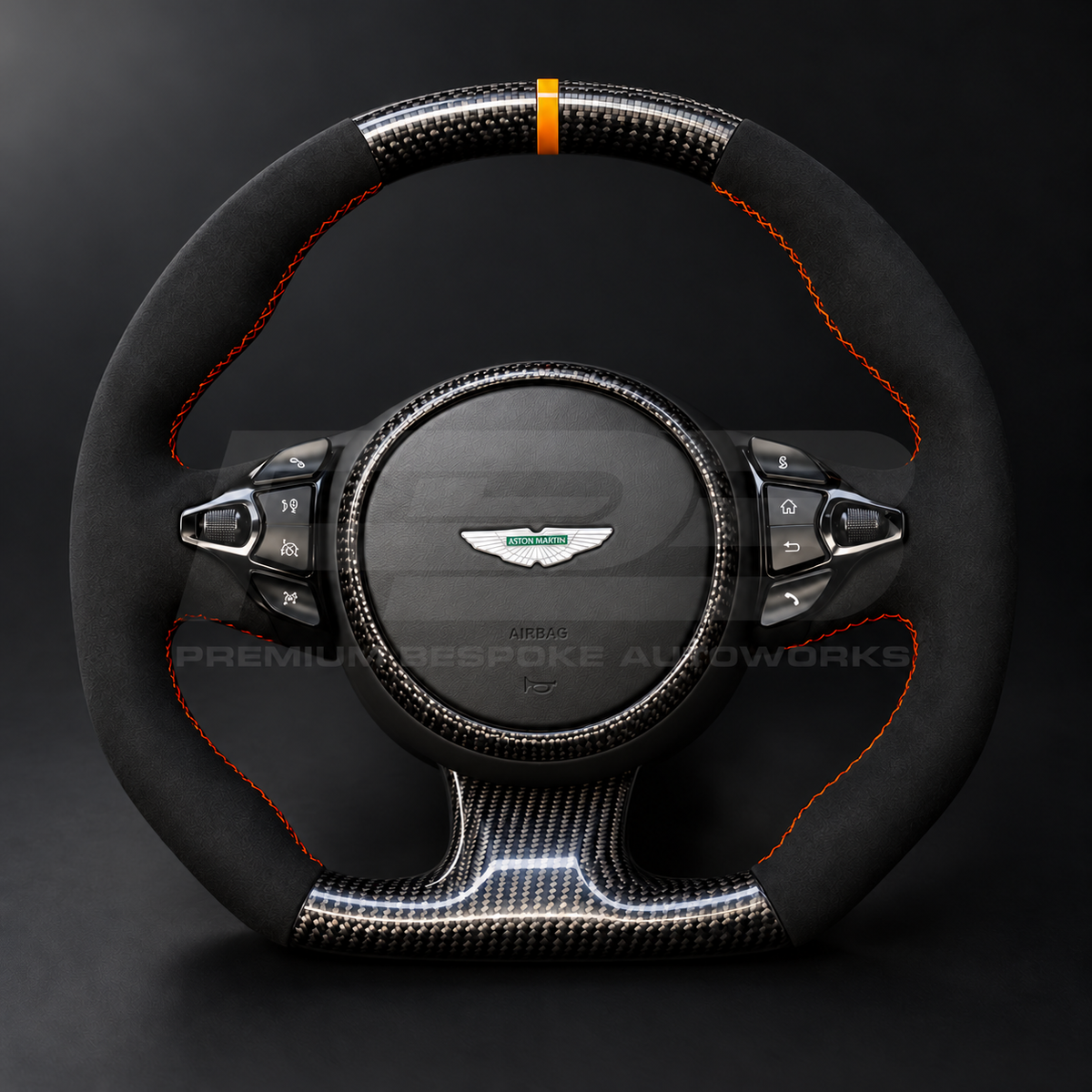 Aston Martin Vantage Facelift custom steering wheel low front view showing flat top and bottom, gloss carbon fibre, black Alcantara grips, orange stitching and orange marker