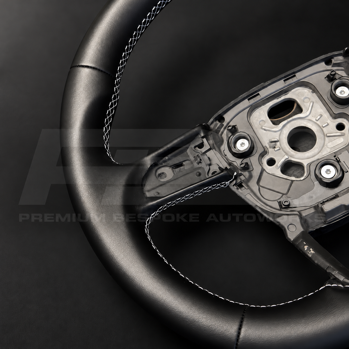 Audi Q8 custom steering wheel, close view of the grey stitching and the thick black nappa leather rim