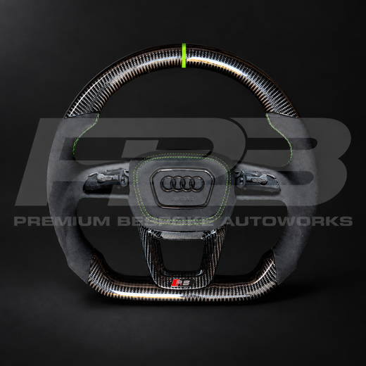 Audi RS3 8Y custom steering wheel, front view: flat bottom, gloss carbon fibre top and bottom, black Alcantara grips, Kyalami green stitching and 12 o'clock marker, Alcantara airbag cover and carbon RS trim