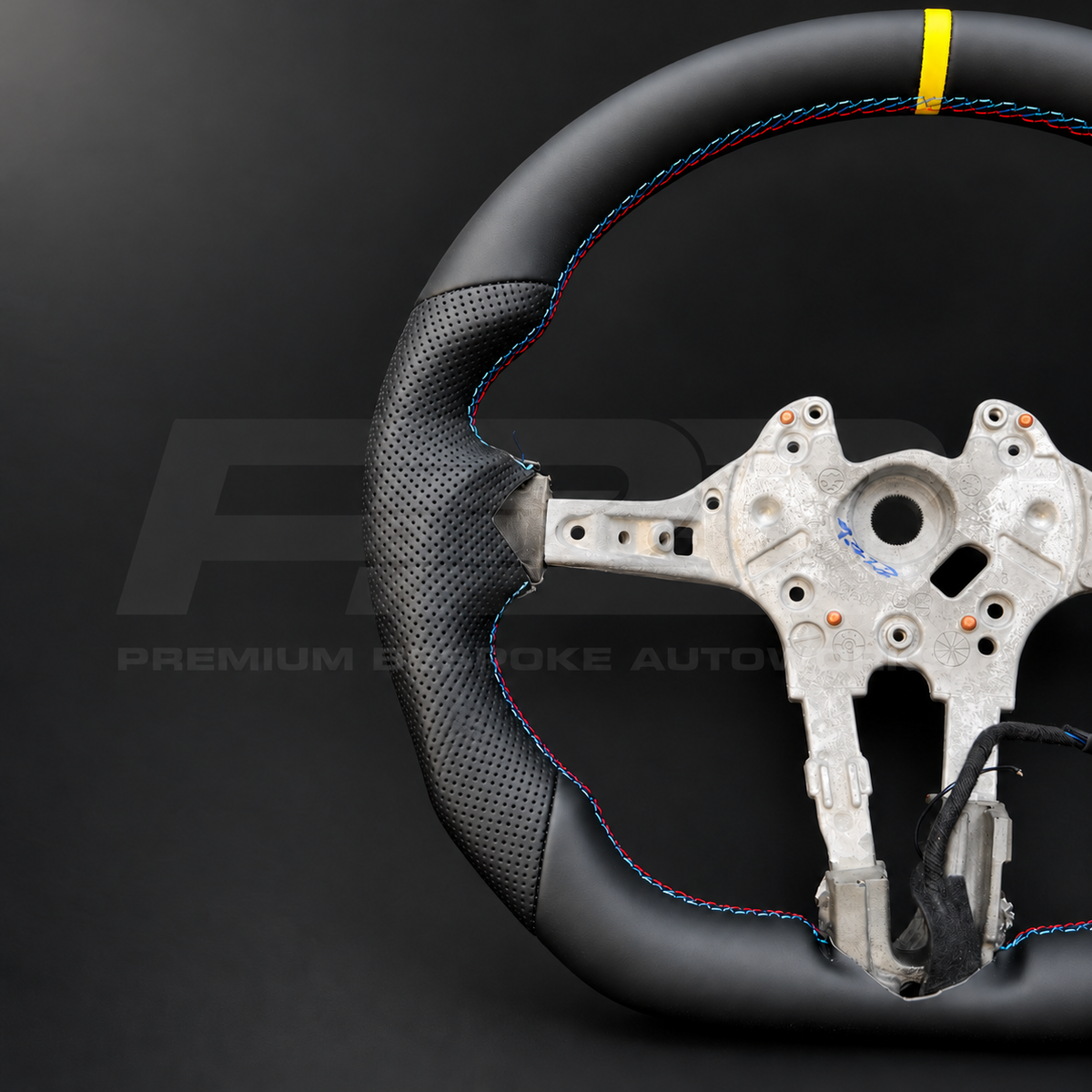 BMW M2 F87 custom steering wheel close up detail showing flat bottom, smooth black leather, black perforated leather grips, M stitching and yellow 12 o'clock marker