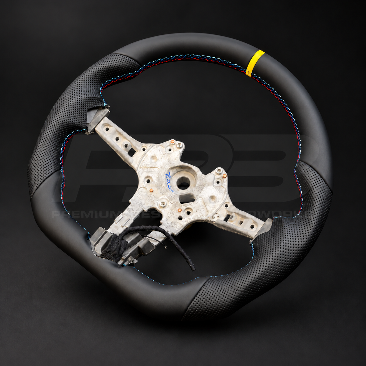 BMW M2 F87 custom steering wheel left angle showing flat bottom, smooth black leather, black perforated leather grips, M stitching and yellow 12 o'clock marker