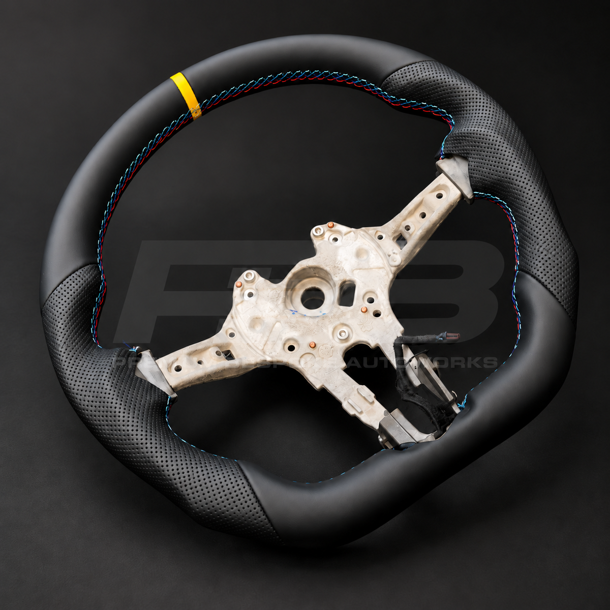BMW M2 F87 custom steering wheel right angle showing flat bottom, smooth black leather, black perforated leather grips, M stitching and yellow 12 o'clock marker