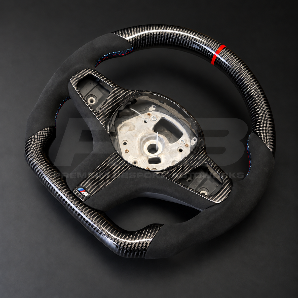 BMW X5 G05 custom steering wheel rotated to show the flat carbon fibre bottom section and carbon lower spoke with M badge