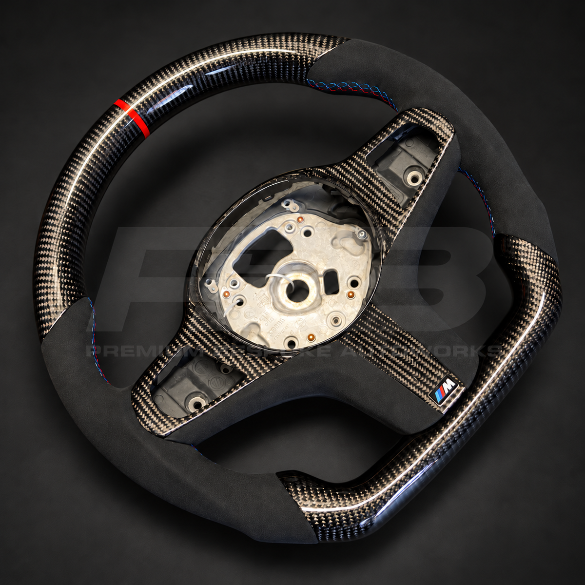 BMW X5 G05 custom steering wheel, angled view showing the black Alcantara grips with M tricolour stitching