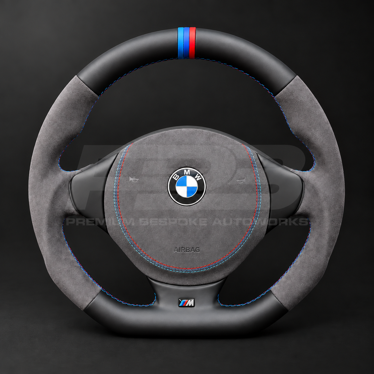 BMW Z3 custom steering wheel front view showing flat bottom, black leather top and bottom, dark grey Alcantara grips and airbag cover, M stitching and M stripe