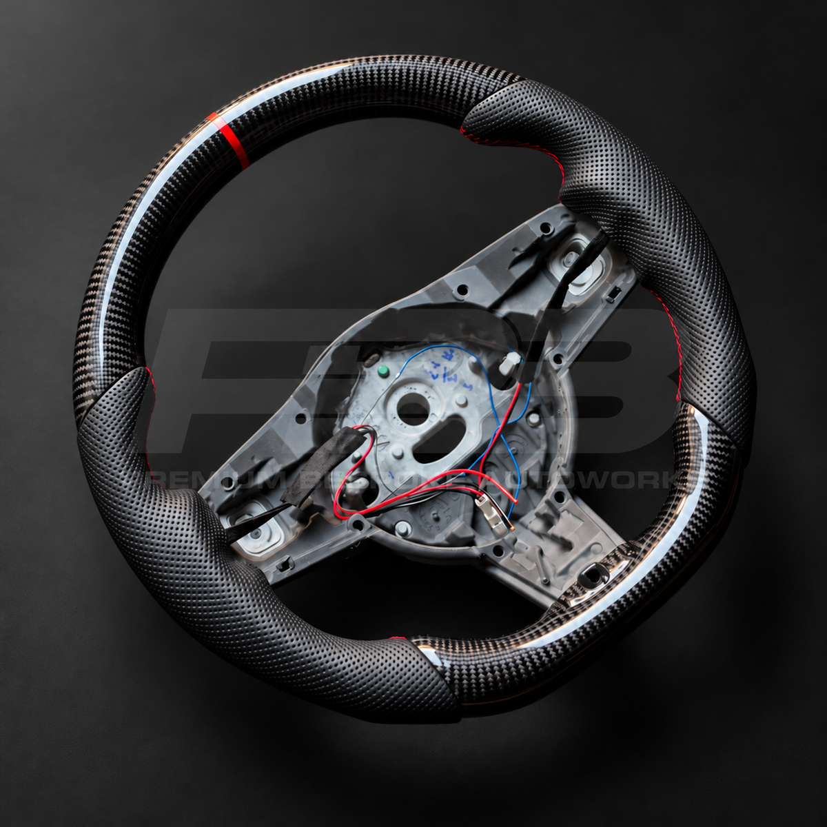 Jaguar F-Type custom steering wheel left angle showing gloss carbon fibre rim, red marker and contoured perforated leather grips