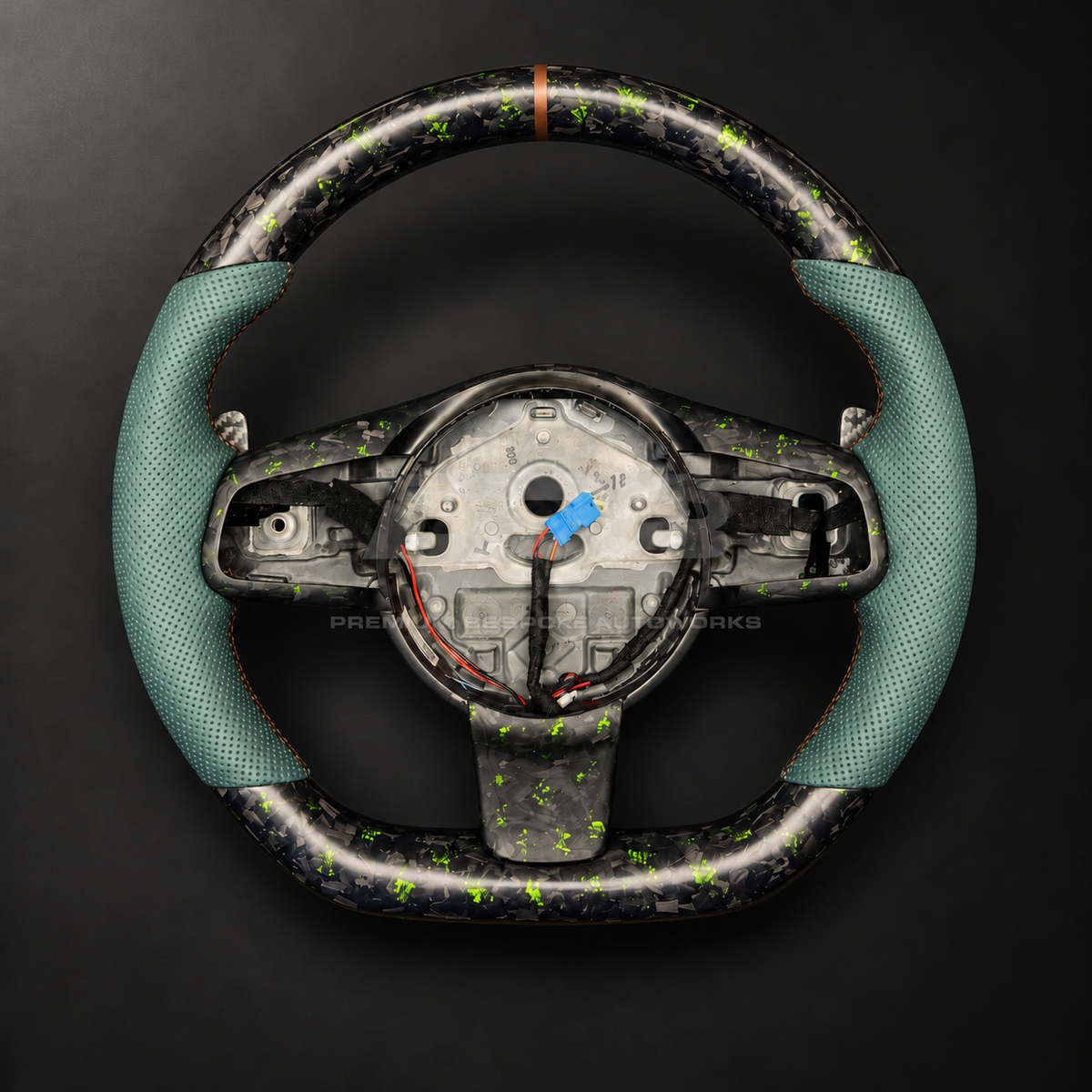 Jaguar F-Type custom steering wheel front view showing sports shape, green fleck forged carbon top and bottom, green perforated leather grips and bronze marker