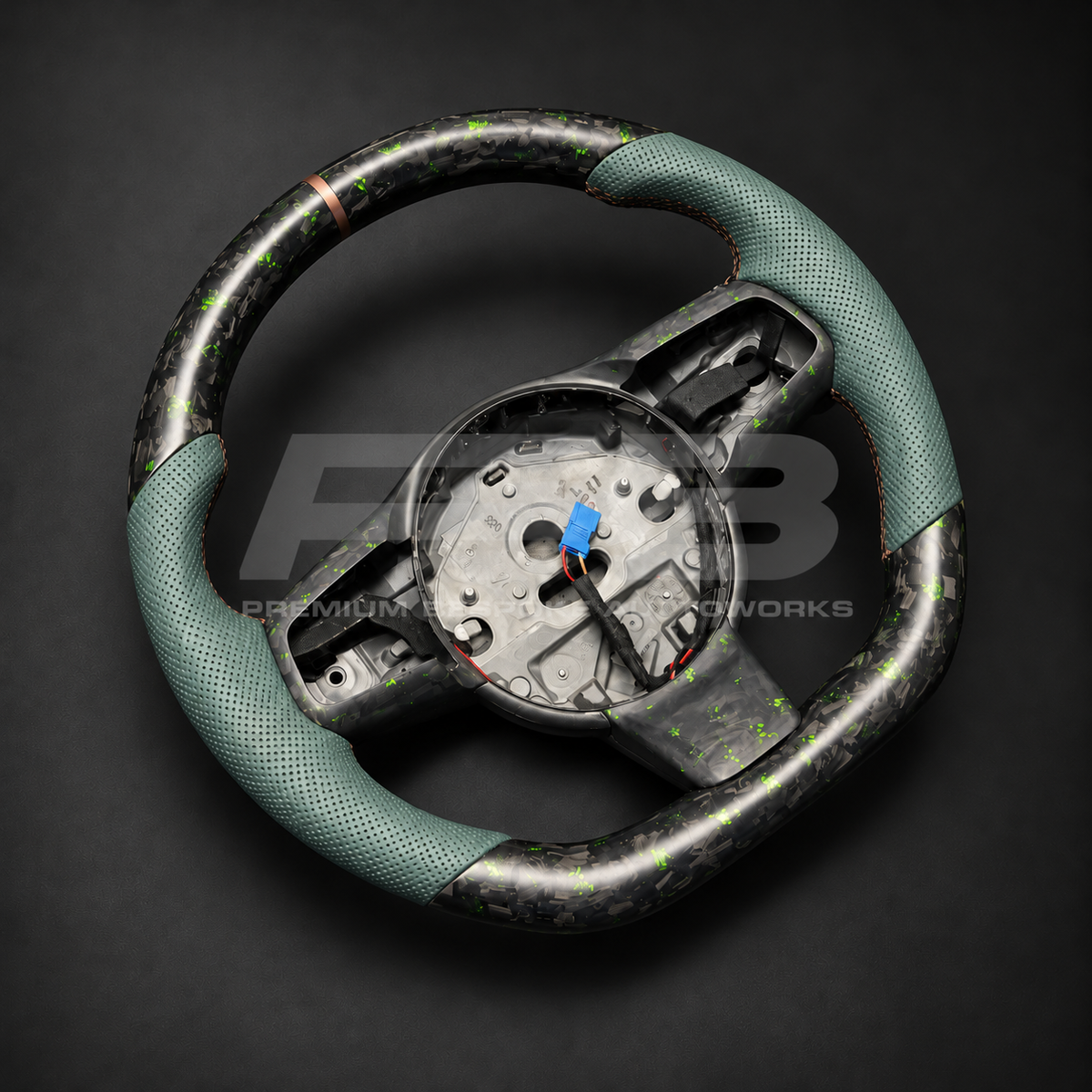 Jaguar F-Type custom steering wheel left angle showing sports shape, green fleck forged carbon top and bottom, green perforated leather grips and bronze marker