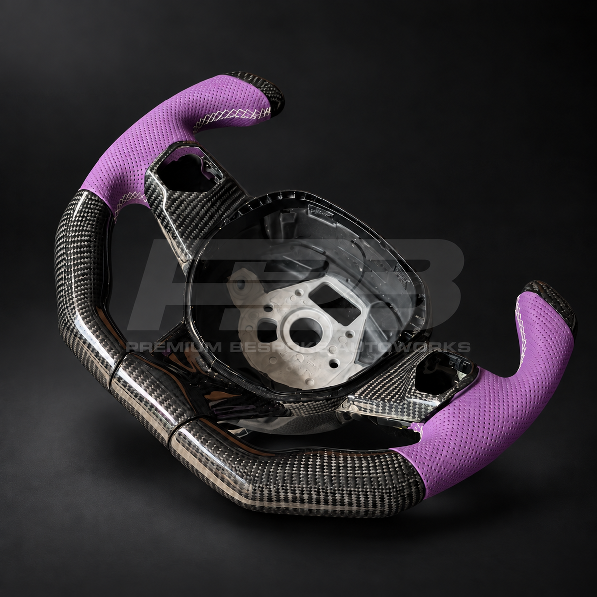 Lamborghini Aventador custom steering wheel, side angle showing the carbon fibre weave, perforated purple leather grip and white stitching detail