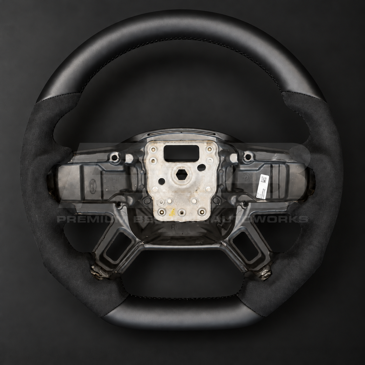 Land Rover Defender L663 custom steering wheel front view, flat bottom, smooth black leather top and bottom with black Alcantara grips