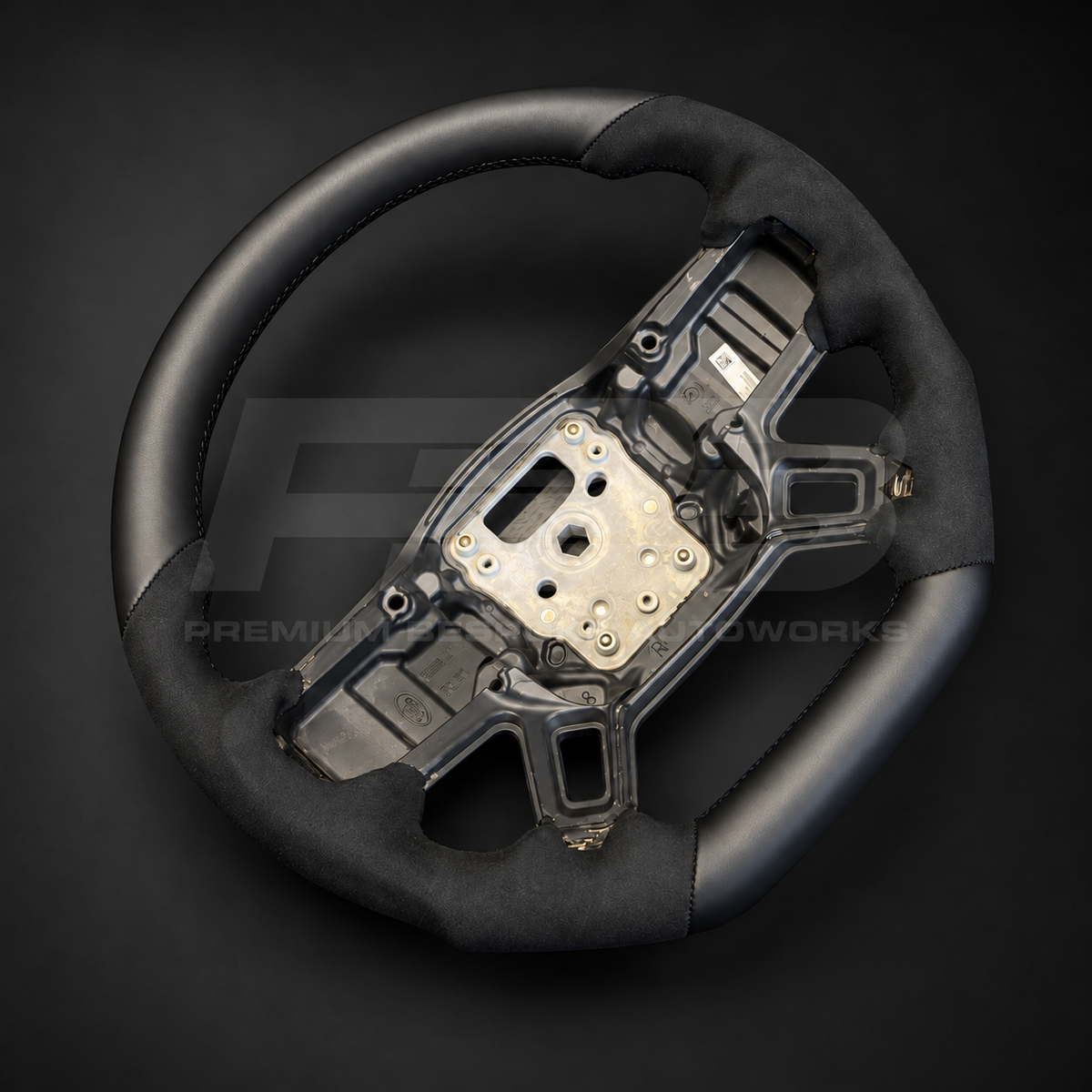 Land Rover Defender L663 custom steering wheel left angle showing smooth leather top section and contoured Alcantara grips