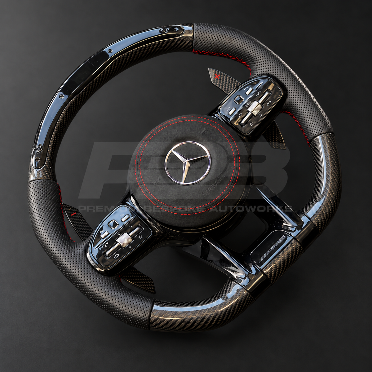 Mercedes-AMG C43 W205 Facelift custom steering wheel left angle showing gloss carbon fibre top and bottom, RPM lights bar, black perforated leather grips, red stitching and Alcantara airbag cover