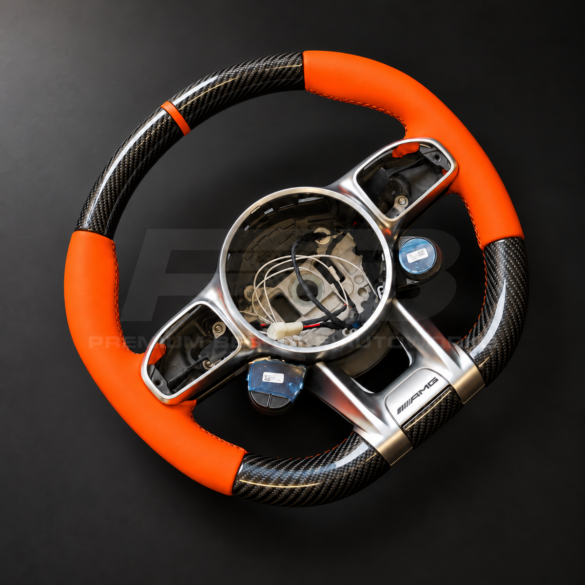Mercedes-AMG G63 W463 Facelift custom steering wheel right angle showing gloss carbon fibre top and bottom, orange leather grips and orange 12 o'clock marker