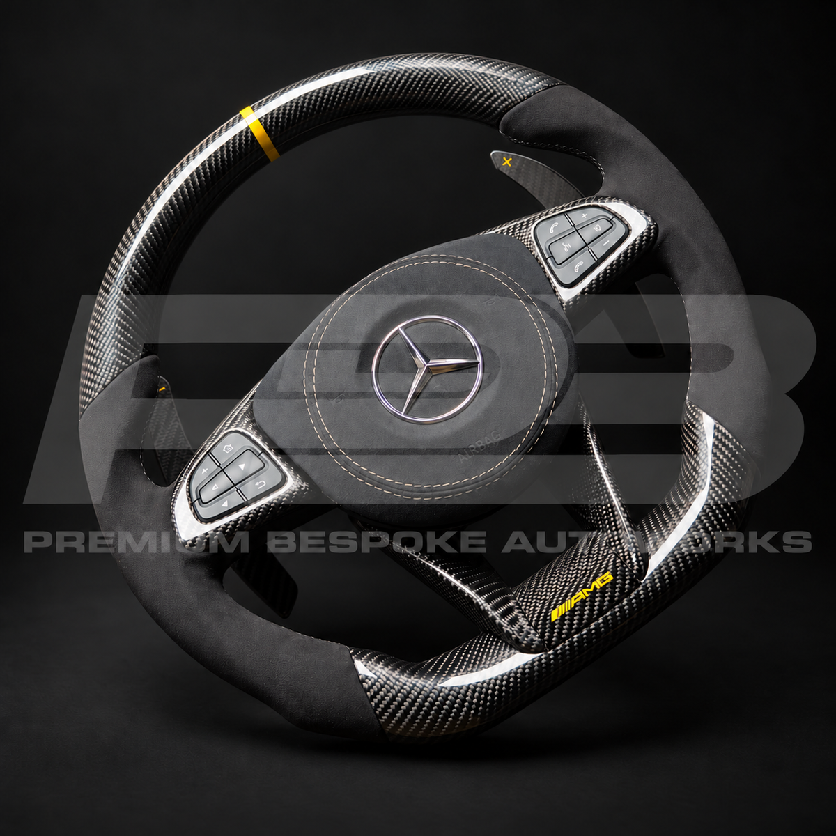 Mercedes-AMG GLE 63 W166 custom steering wheel from the opposite angle, gloss carbon fibre top and bottom, Alcantara grips and gold AMG badge on the lower carbon trim