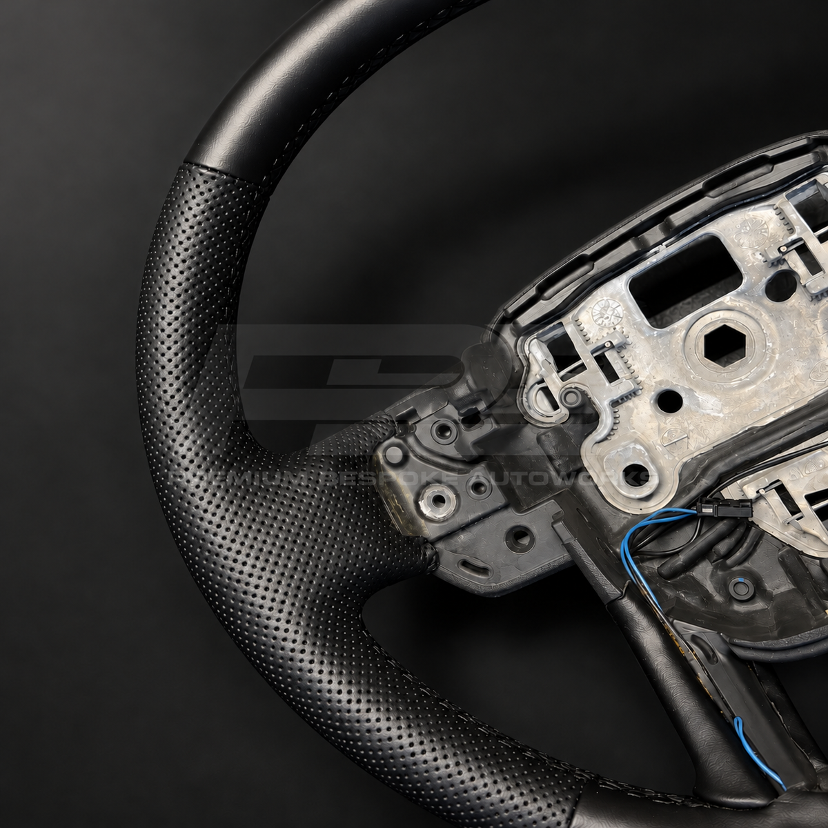 Range Rover Sport L494 custom steering wheel, close view of the perforated black leather grip and black stitching