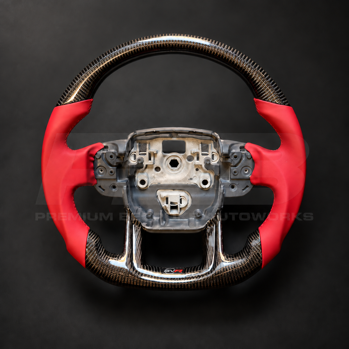 Range Rover Sport L494 SVR custom steering wheel front view, flat bottom, gloss carbon fibre top and bottom, SVR red leather grips and stitching, carbon lower trim with SVR badge