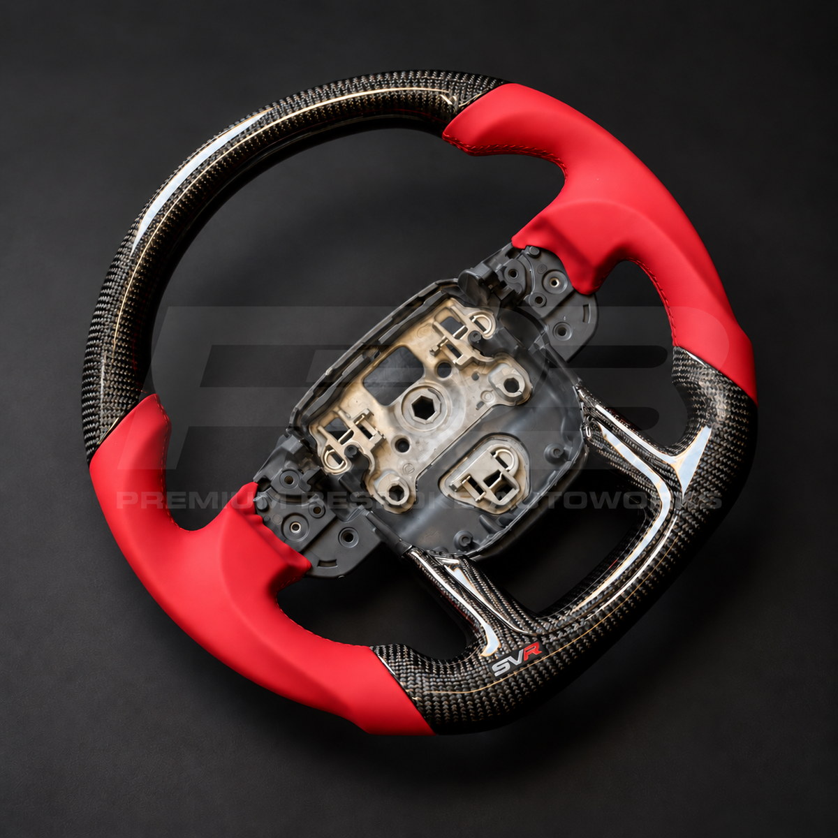 Range Rover Sport L494 SVR custom steering wheel left angle showing flat bottom, gloss carbon fibre top and bottom, SVR red leather grips and stitching, carbon lower trim with SVR badge