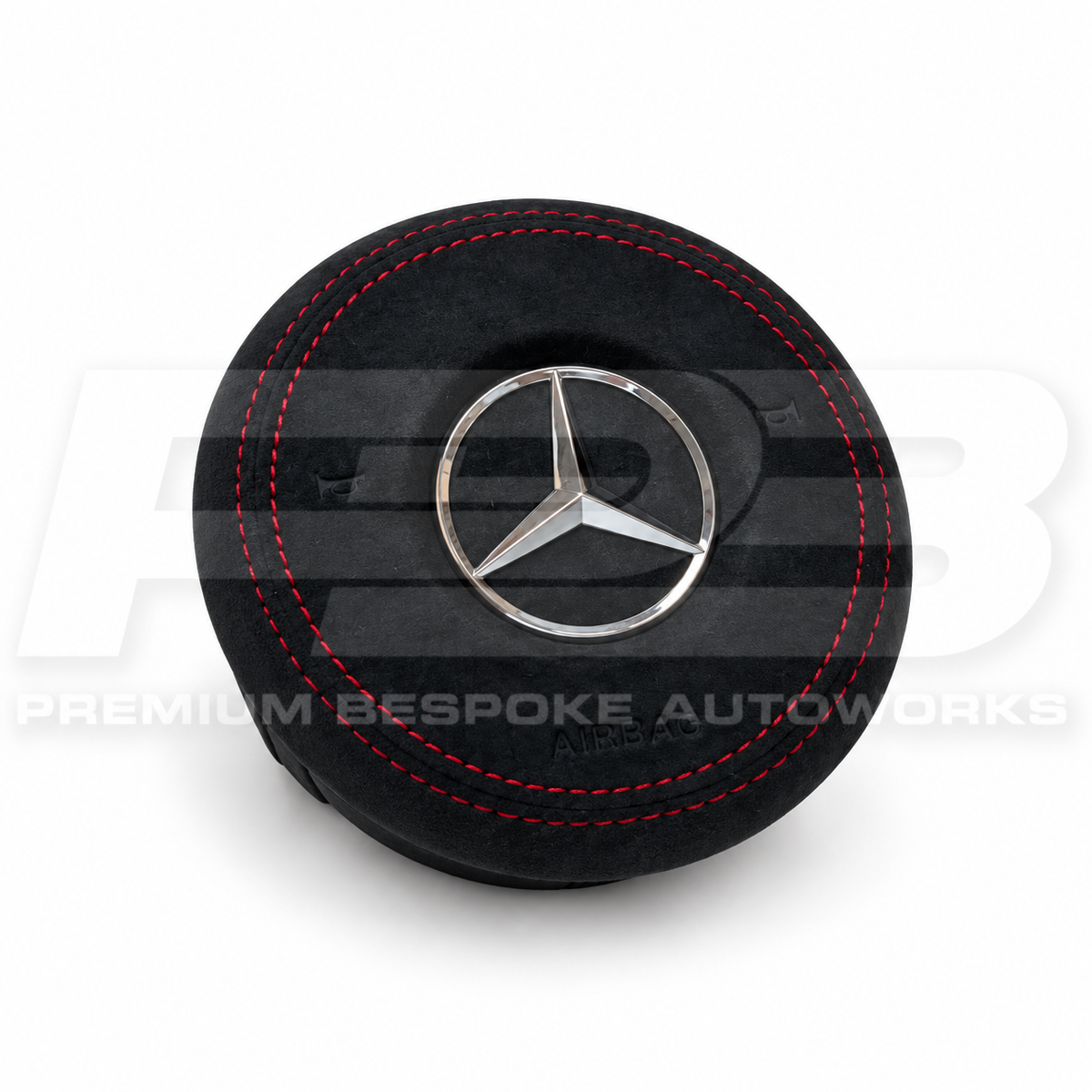 Mercedes A45 AMG W177 custom airbag cover in black Alcantara with red stitching, angled view showing the fit over the original airbag unit