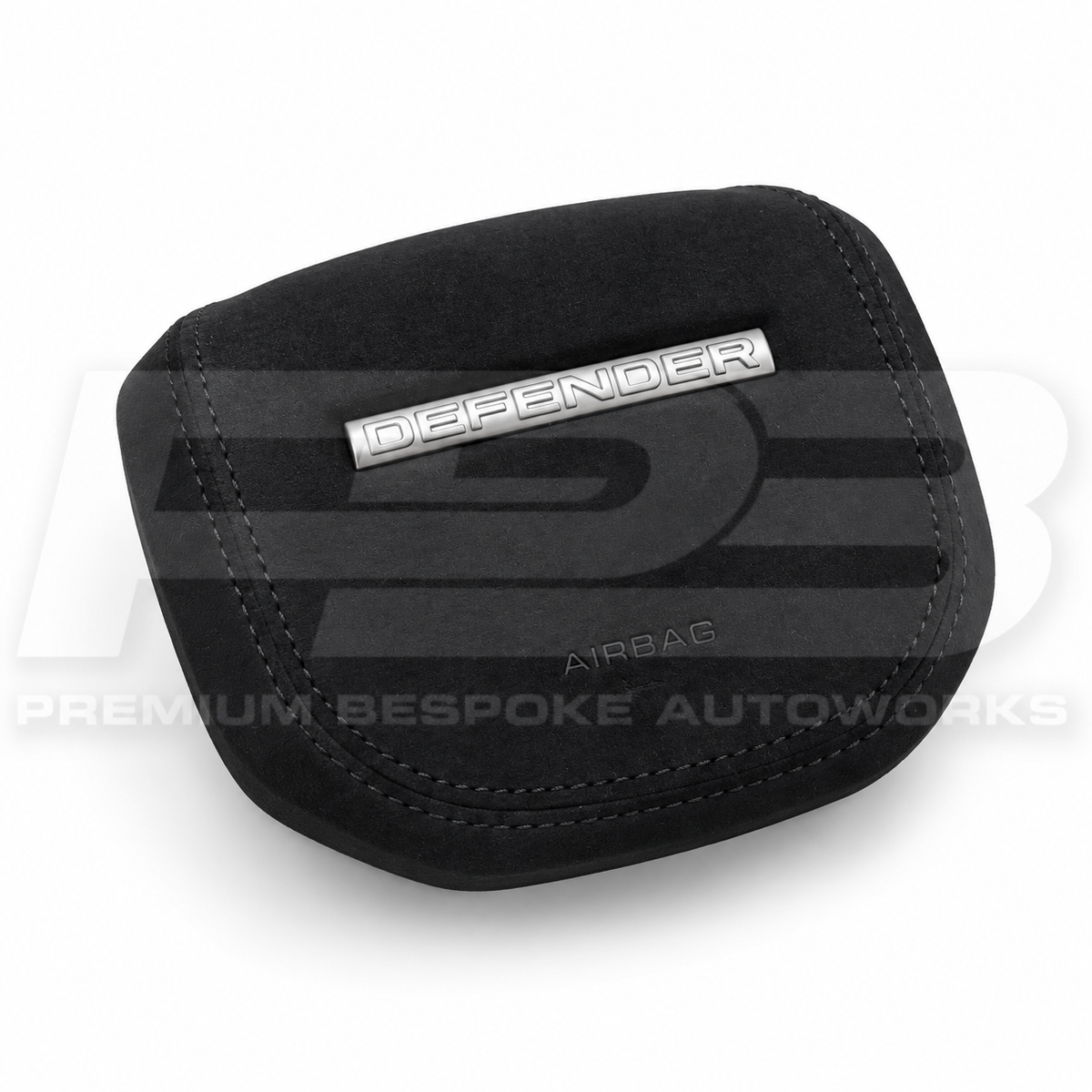 Land Rover Defender L663 custom airbag cover in black Alcantara, angled view showing the fit over the original airbag unit