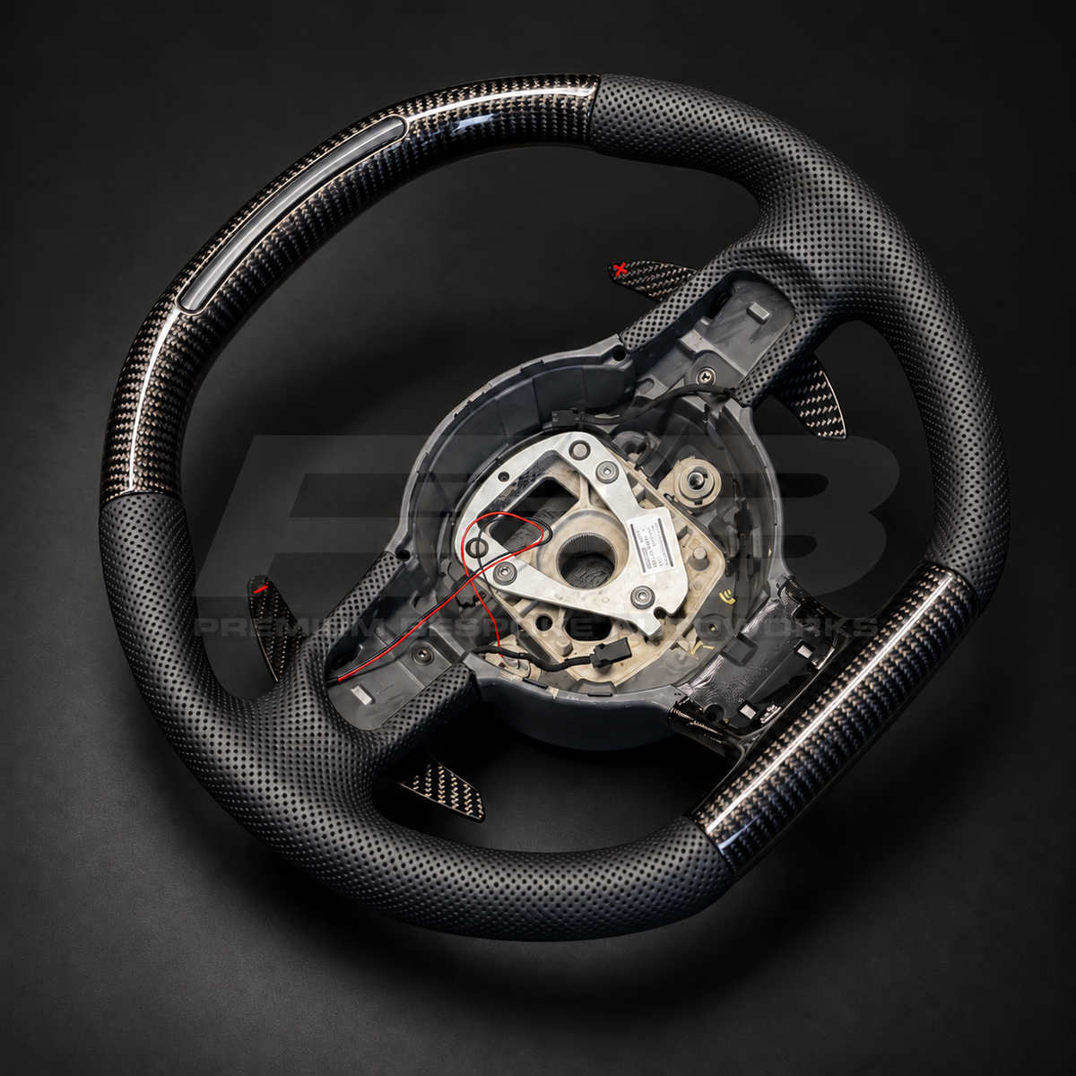 Audi R8 Gen 1 custom steering wheel rotated to show the gloss carbon fibre top section with RPM light bar and perforated leather grips