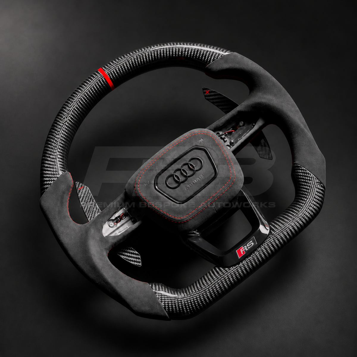 Audi RS3 8Y custom steering wheel left angle showing flat bottom, gloss carbon fibre top and bottom, red marker, black Alcantara grips and airbag cover with red stitching