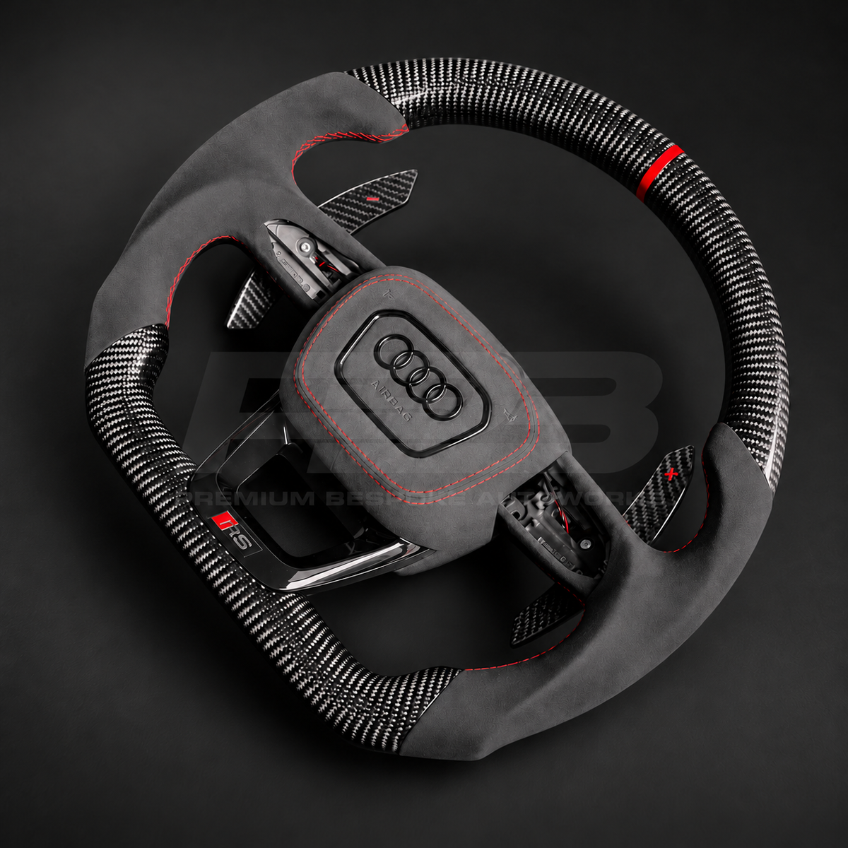 Audi RS3 8Y custom steering wheel right angle showing flat bottom, gloss carbon fibre top and bottom, red marker, black Alcantara grips and airbag cover with red stitching