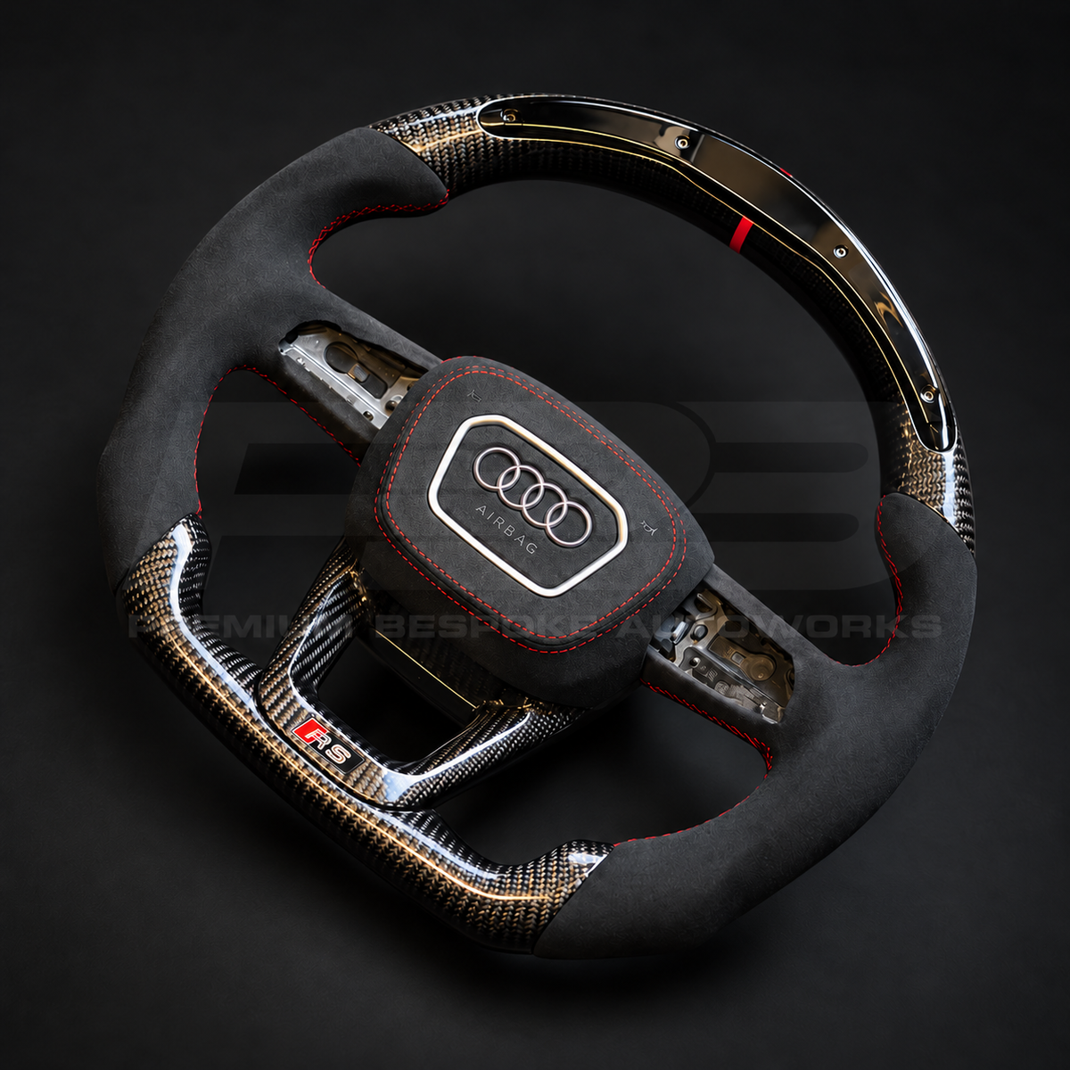 Audi RS4 B9.5 custom steering wheel rotated to show the flat carbon fibre bottom section and the Alcantara airbag cover with red stitching