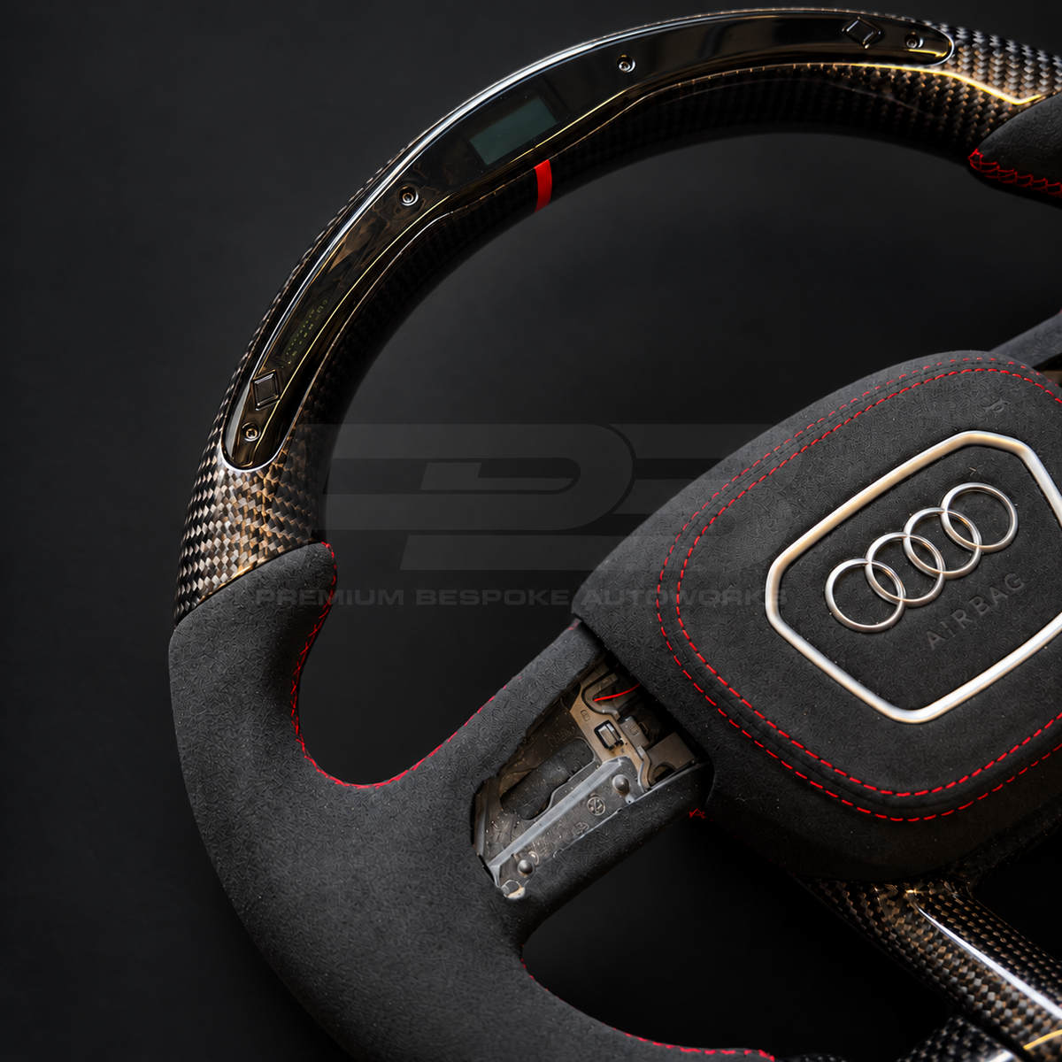 Audi RS4 B9.5 custom steering wheel, close angled view of the LED race display window, red marker, carbon fibre weave and Alcantara grip