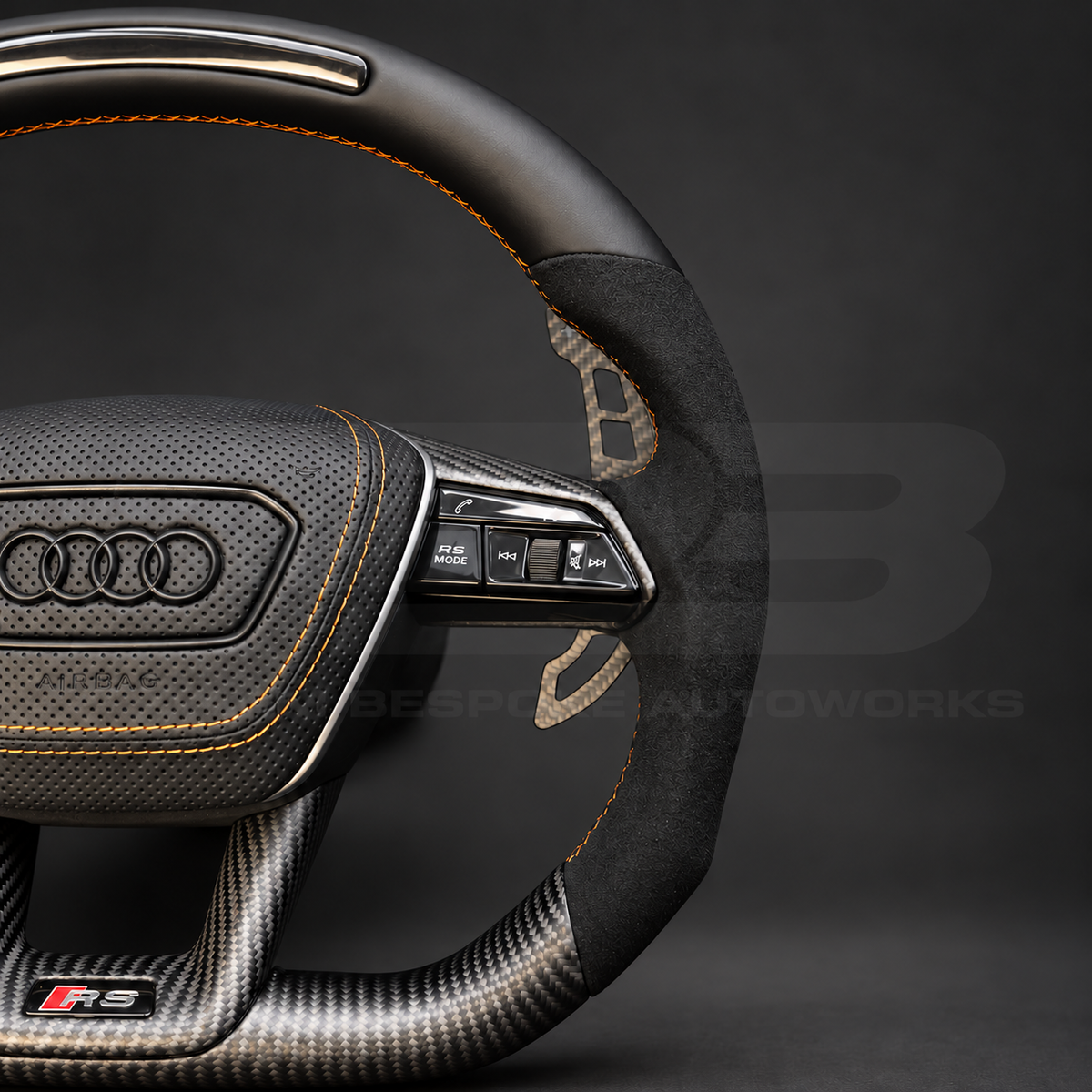 Audi RS7 4K8 custom steering wheel close up detail showing black Nappa leather top with RPM lights, matte carbon bottom, Alcantara grips and copper stitching