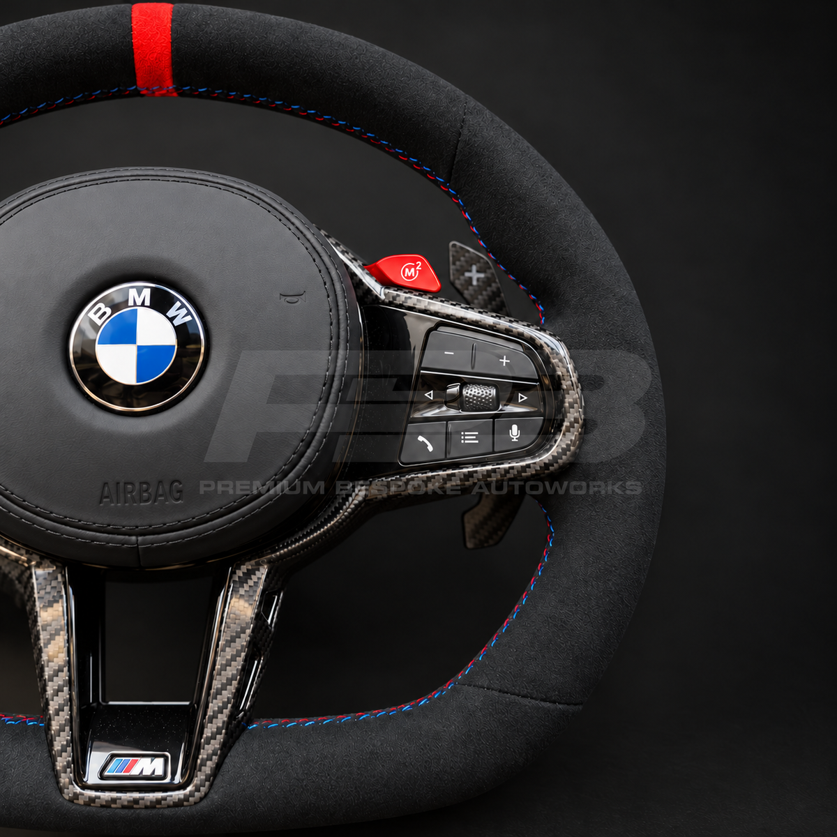 BMW M4 G82 LCI custom steering wheel close up detail showing full black Alcantara, red 12 o'clock marker, M tricolour stitching, Alcantara airbag cover, carbon trims, red M buttons