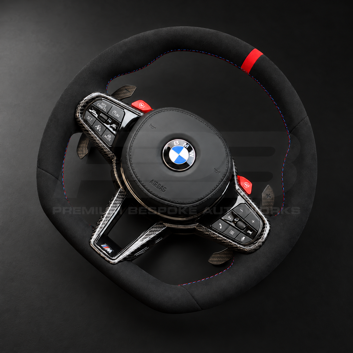 BMW M4 G82 LCI custom steering wheel right angle showing full black Alcantara, red 12 o'clock marker, M tricolour stitching, Alcantara airbag cover, carbon trims, red M buttons