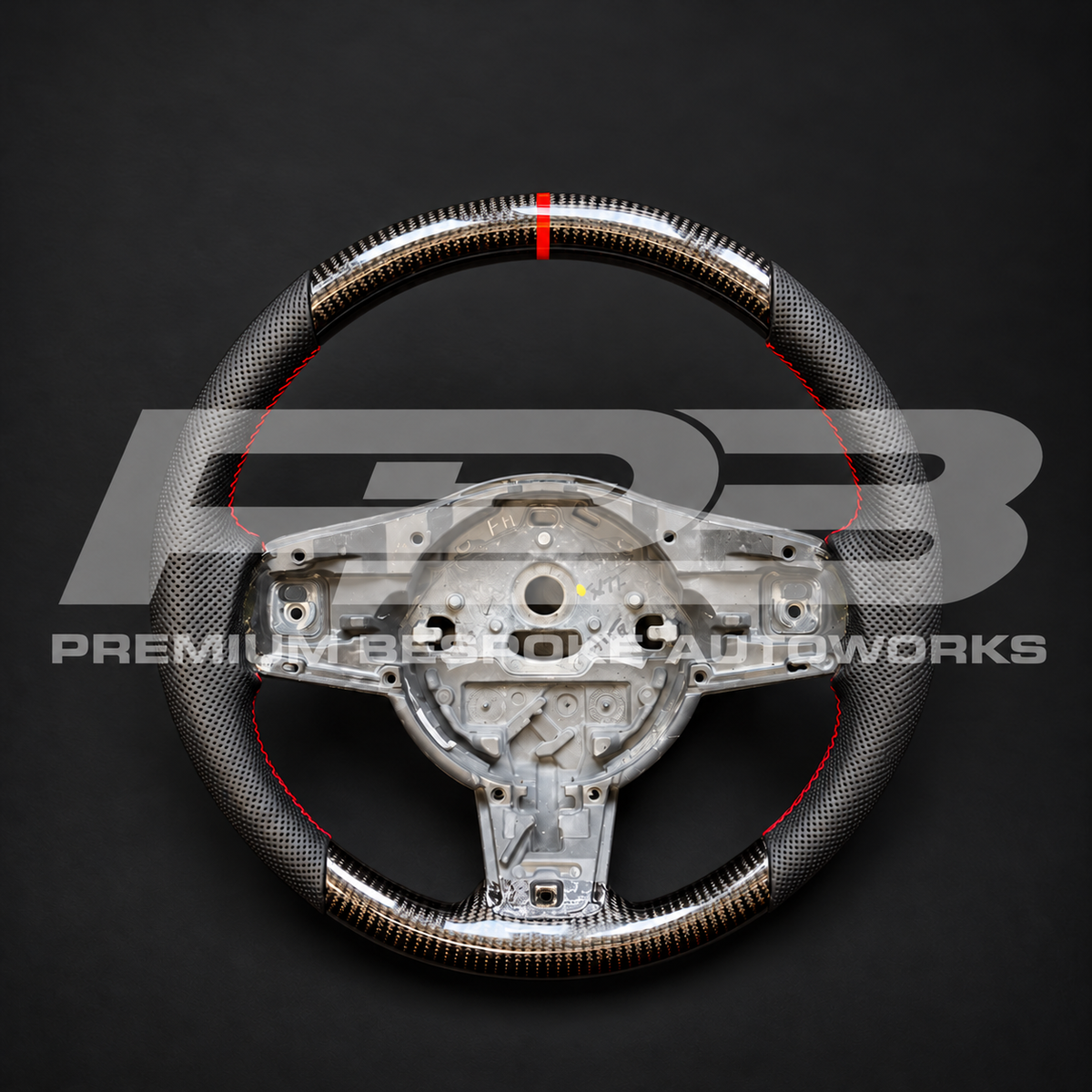 Jaguar F-Type custom steering wheel, front view: OEM shape, gloss carbon fibre top and bottom, perforated black leather grips, red stitching and red 12 o'clock marker