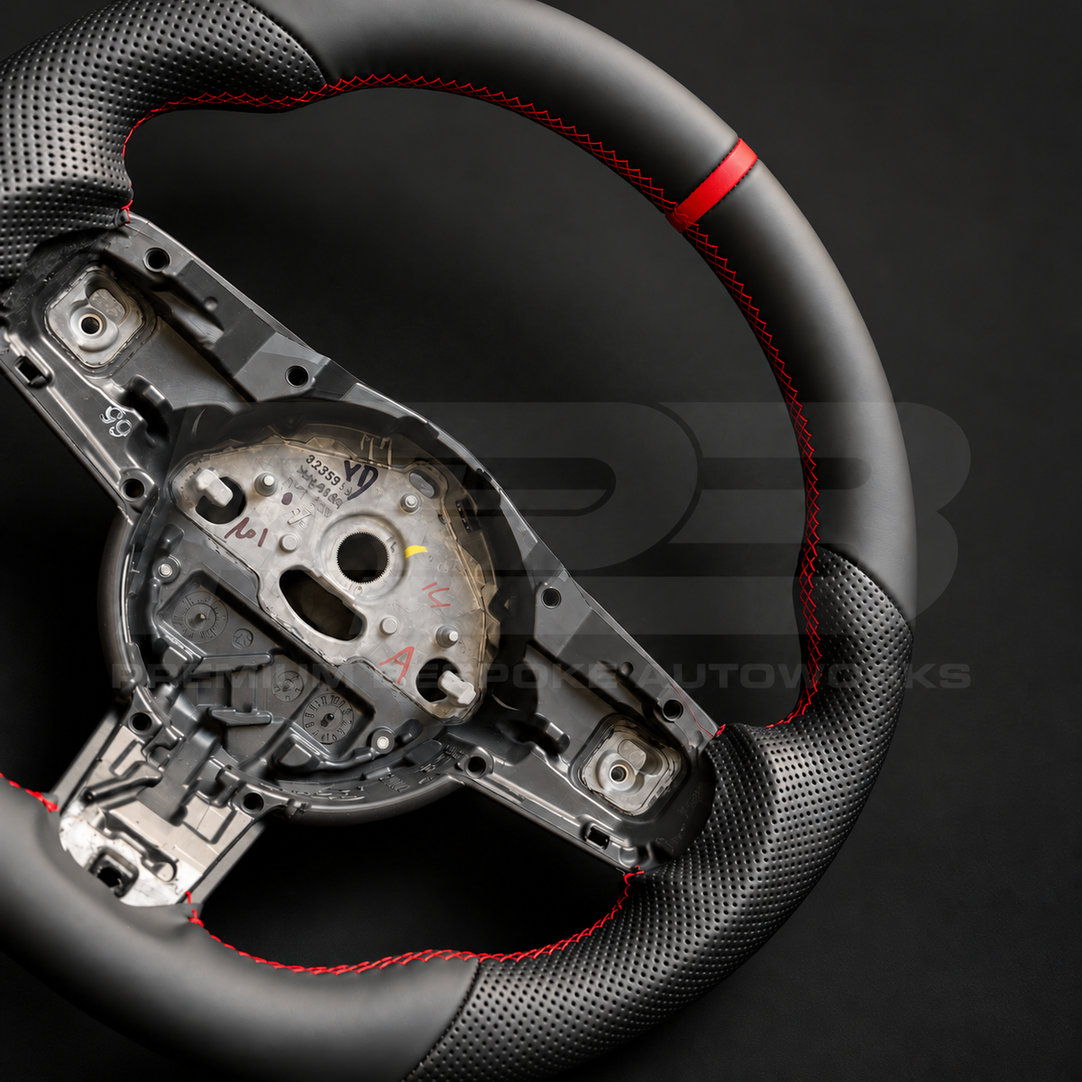 Close up of Jaguar F-Type custom steering wheel red 12 o'clock marker and red stitching between smooth and perforated black leather