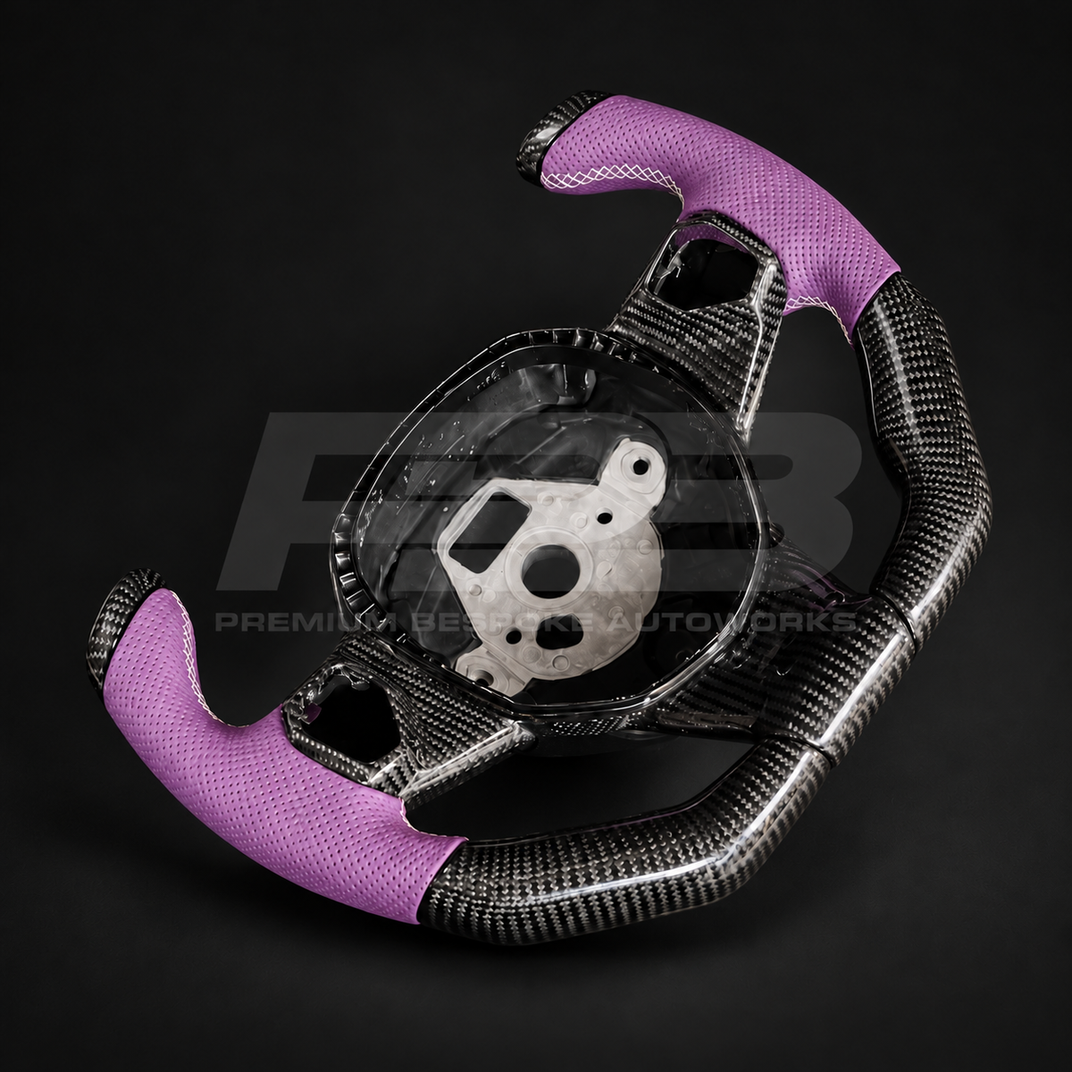 Lamborghini Aventador custom steering wheel tilted to show the gloss carbon fibre bottom section and purple perforated leather grips