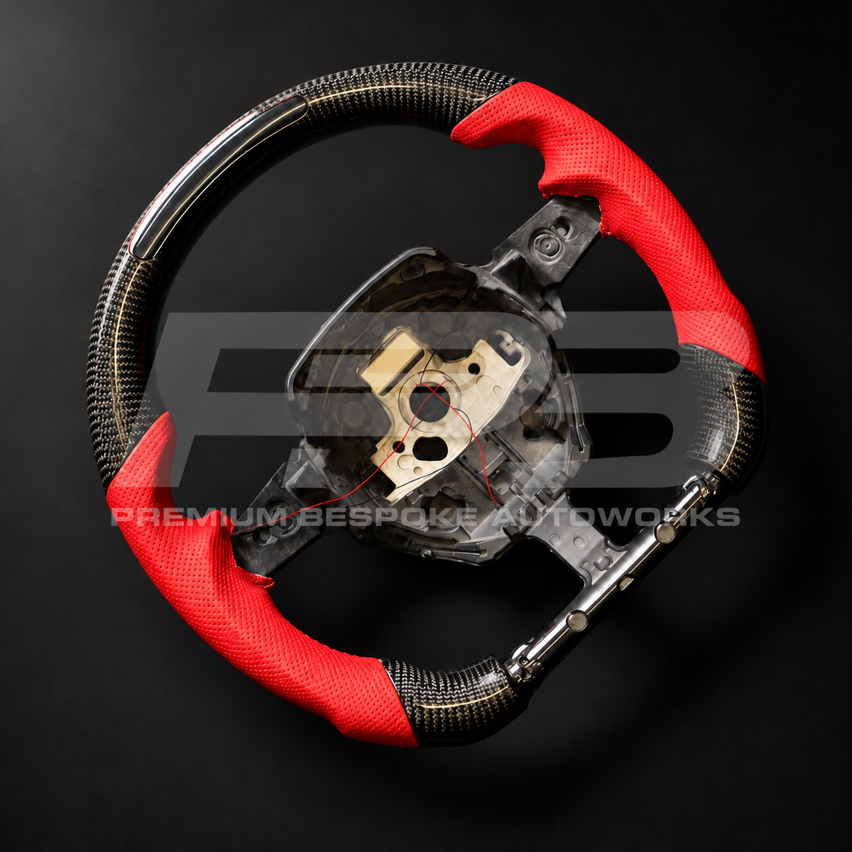 Lamborghini Huracan custom steering wheel angled from the left, gloss carbon fibre with red perforated leather grips