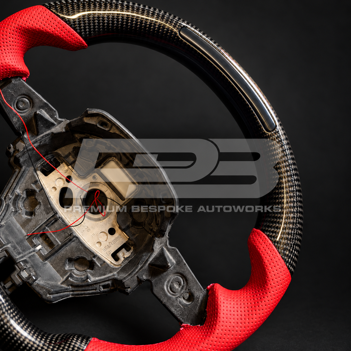 Close up of the RPM light bar set into the gloss carbon fibre flat top section and the red perforated grip on a Lamborghini Huracan custom steering wheel