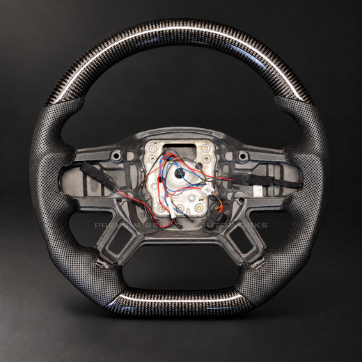 Land Rover Defender L663 custom steering wheel, front view, flat bottom gloss carbon fibre with perforated black leather grips and black stitching, heated, customer build by Premium Bespoke AutoWorks