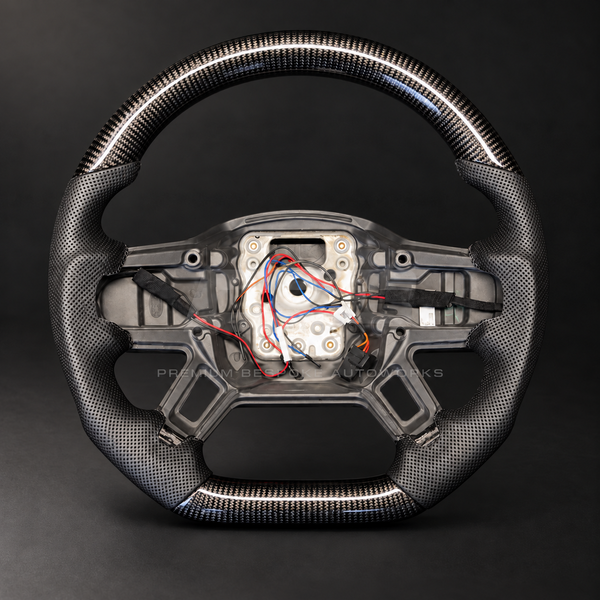 Land Rover Defender L663 custom steering wheel, front view, flat bottom gloss carbon fibre with perforated black leather grips and black stitching, heated, customer build by Premium Bespoke AutoWorks