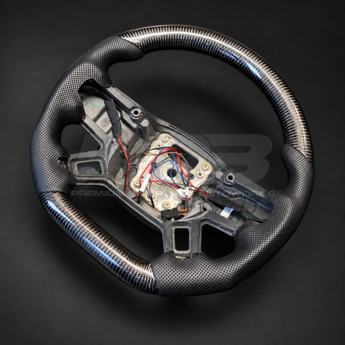 Land Rover Defender L663 custom steering wheel rotated to show the flat carbon fibre bottom section and lower spokes