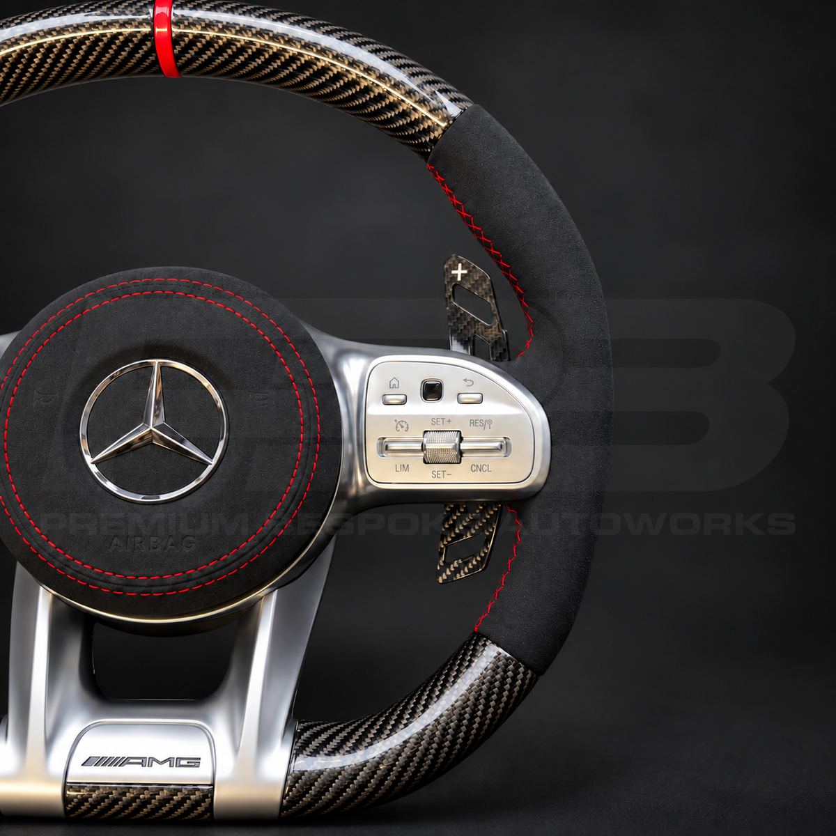 Mercedes-AMG A45 W177 custom steering wheel close up detail showing gloss carbon fibre, black Alcantara grips and airbag cover, red stitching and red marker