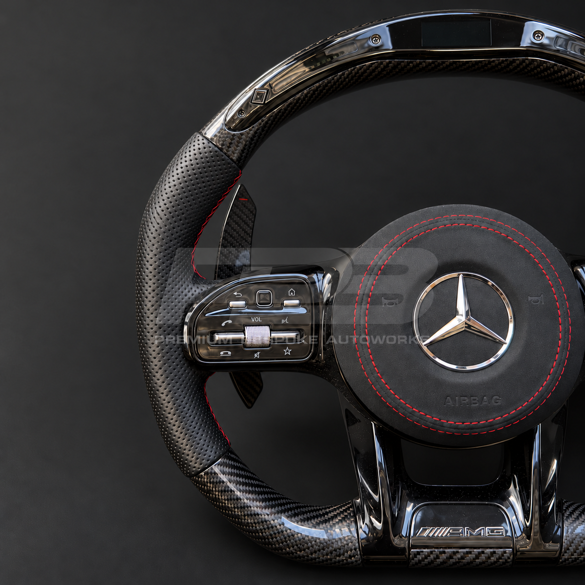 Mercedes-AMG C43 W205 Facelift custom steering wheel close up detail showing gloss carbon fibre top and bottom, RPM lights bar, black perforated leather grips, red stitching and Alcantara airbag cover