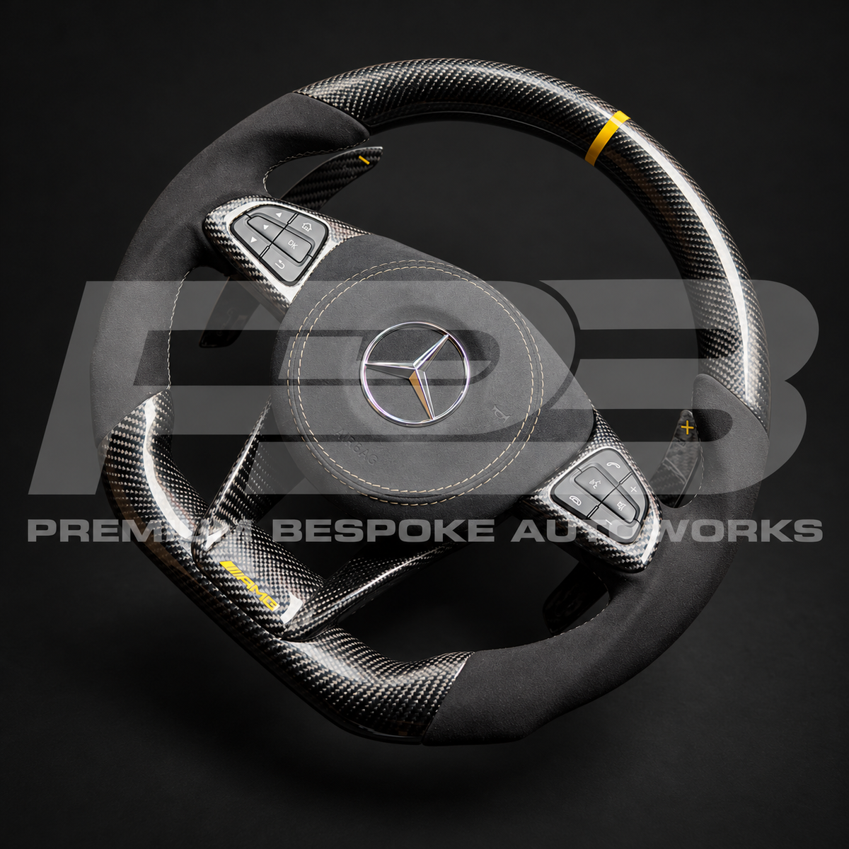 Mercedes-AMG GLE 63 W166 flat bottom carbon fibre and Alcantara custom steering wheel at an angle, showing the carbon button surrounds and paddle shifters