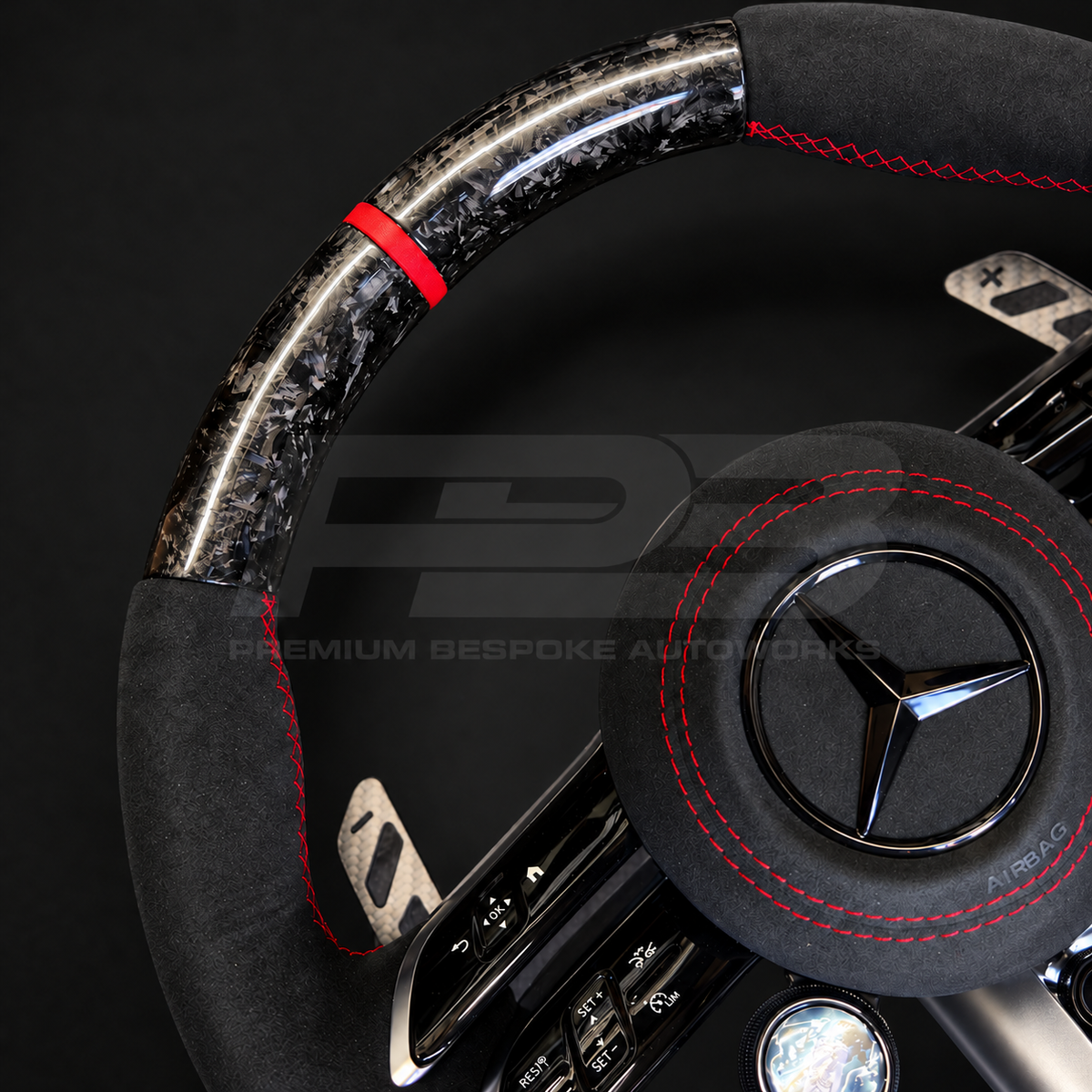 Mercedes-AMG CLA 45 S custom steering wheel, close view of the red 12 o'clock marker, marbled forged carbon weave and red stitched Alcantara grip