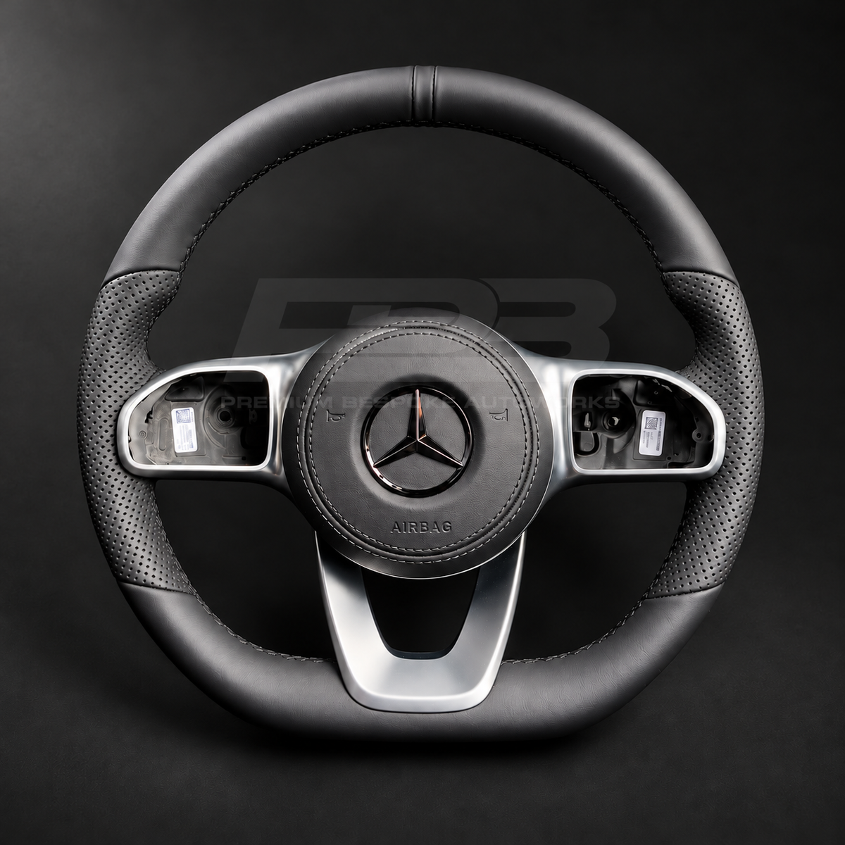Mercedes-Benz CLS C257 custom steering wheel front view, flat bottom, smooth black leather, perforated grips, black stitching, leather airbag cover, factory silver spokes
