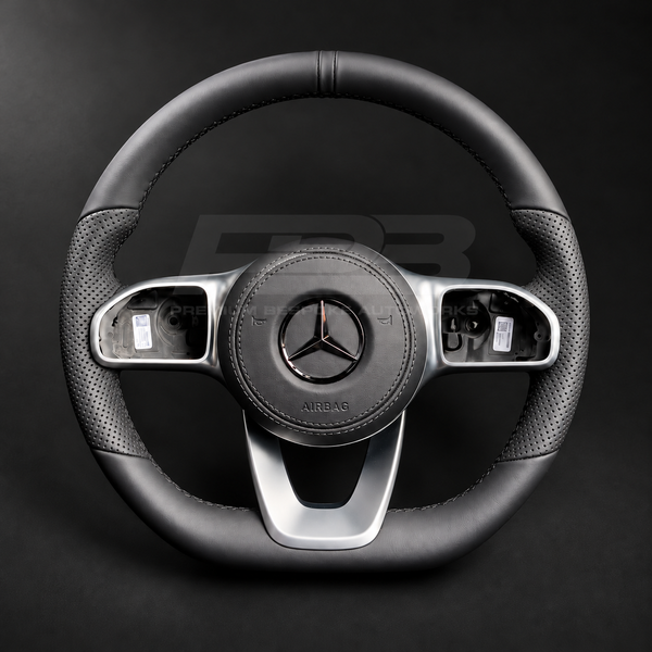 Mercedes-Benz CLS C257 custom steering wheel front view, flat bottom, smooth black leather, perforated grips, black stitching, leather airbag cover, factory silver spokes