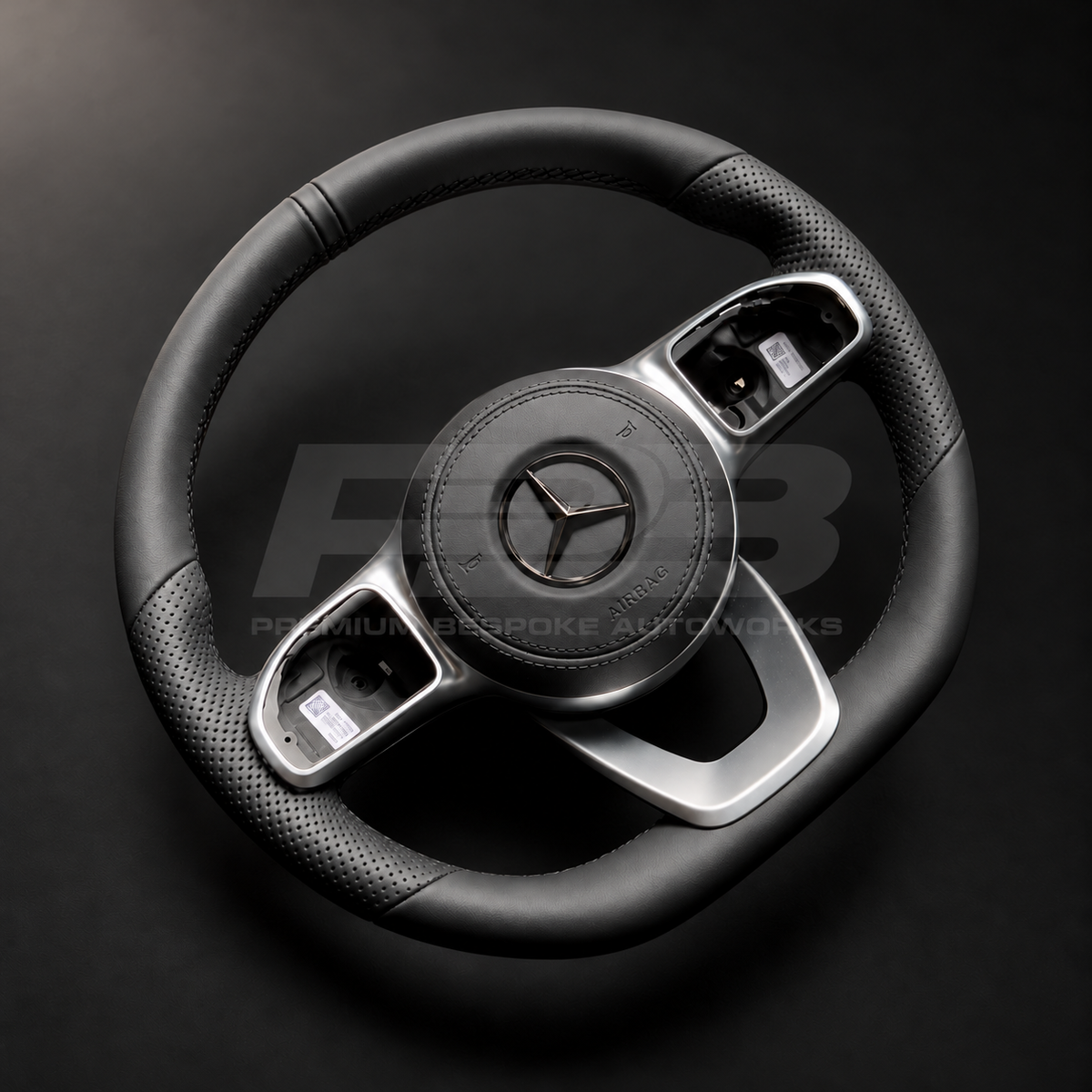 Mercedes-Benz CLS C257 custom steering wheel left angle showing flat bottom, smooth black leather, perforated grips, black stitching, leather airbag cover, factory silver spokes