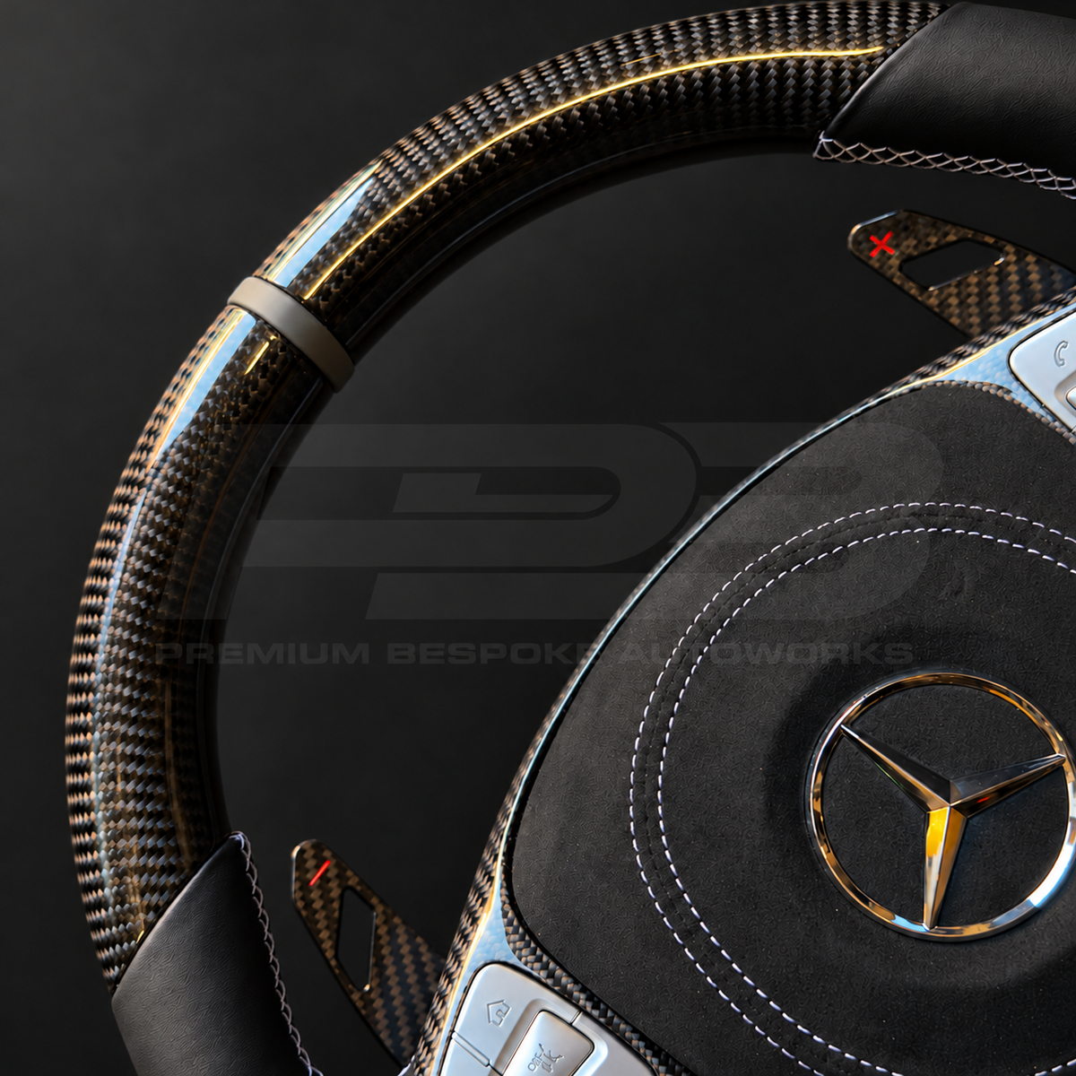 Close up of Mercedes-AMG S63 W222 custom steering wheel grey 12 o'clock marker, carbon fibre rim and carbon paddle with red shift marking