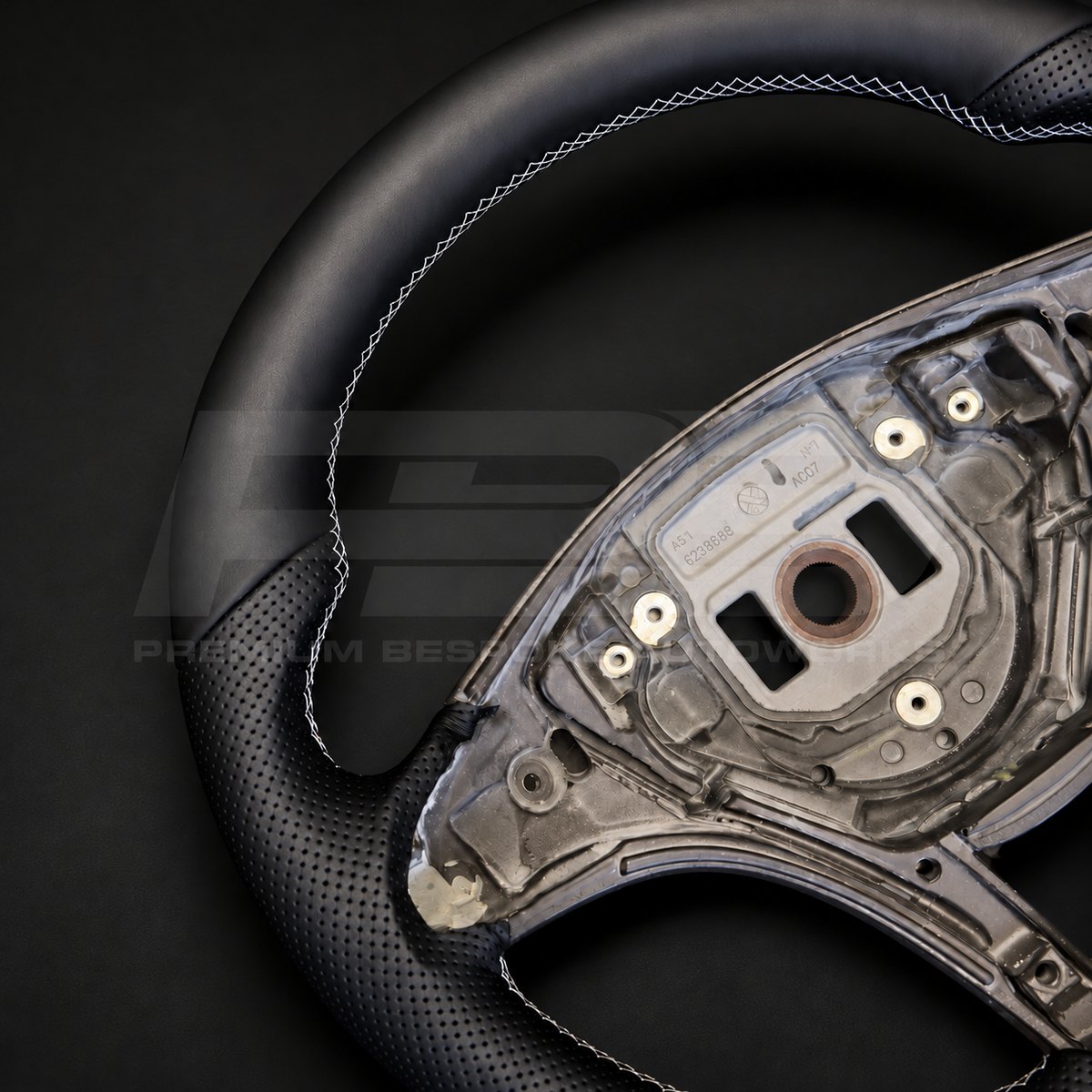 Mercedes X-Class custom steering wheel close up detail showing flat bottom, black smooth leather top and bottom, black perforated leather grips and light grey stitching