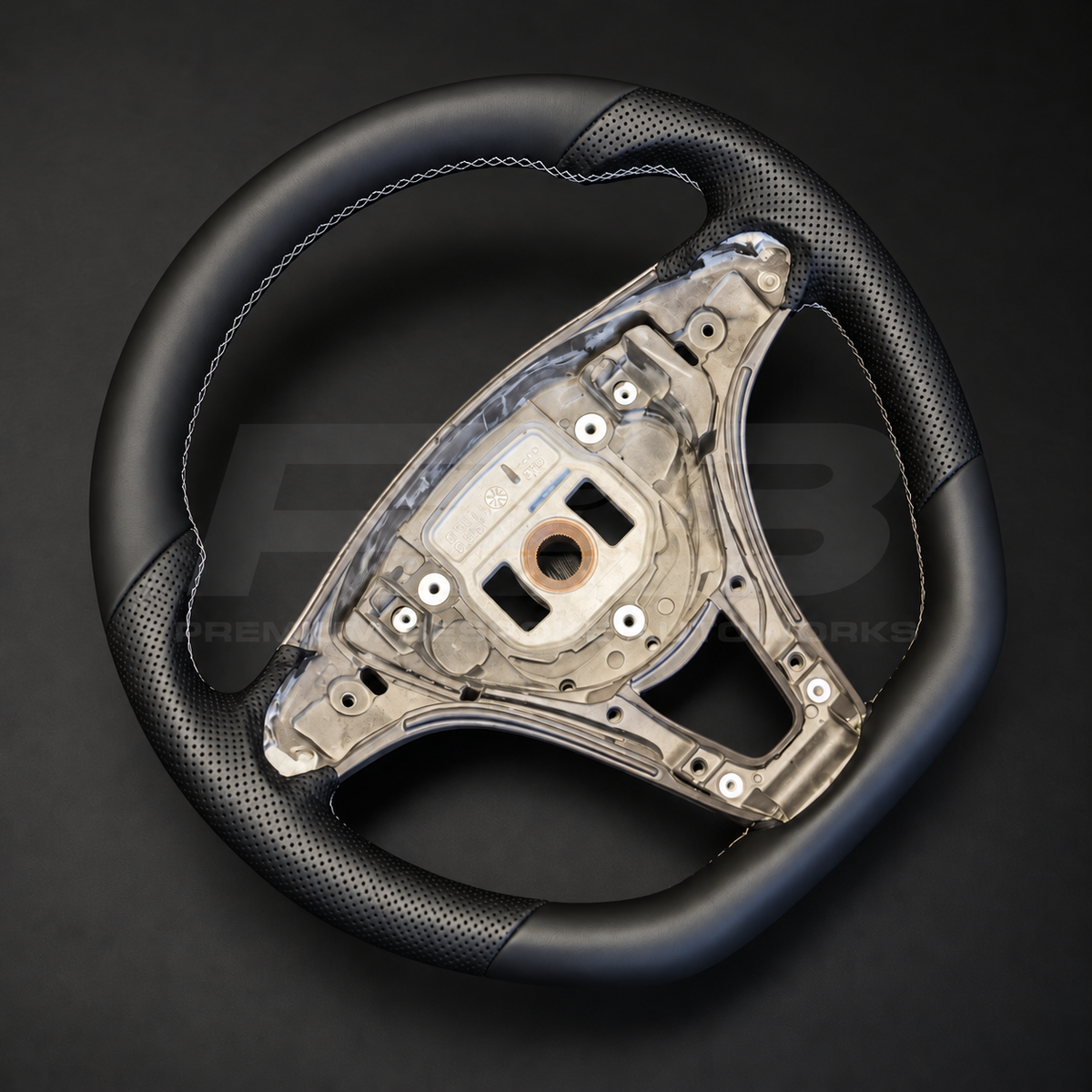 Mercedes X-Class custom steering wheel left angle showing flat bottom, black smooth leather top and bottom, black perforated leather grips and light grey stitching