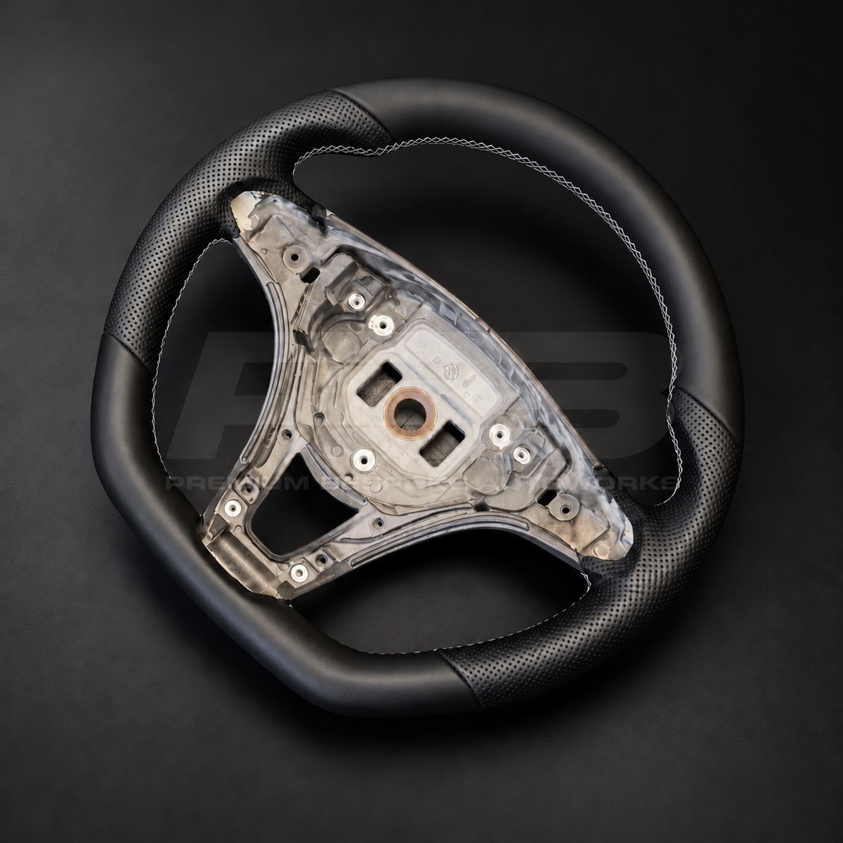Mercedes X-Class custom steering wheel right angle showing flat bottom, black smooth leather top and bottom, black perforated leather grips and light grey stitching